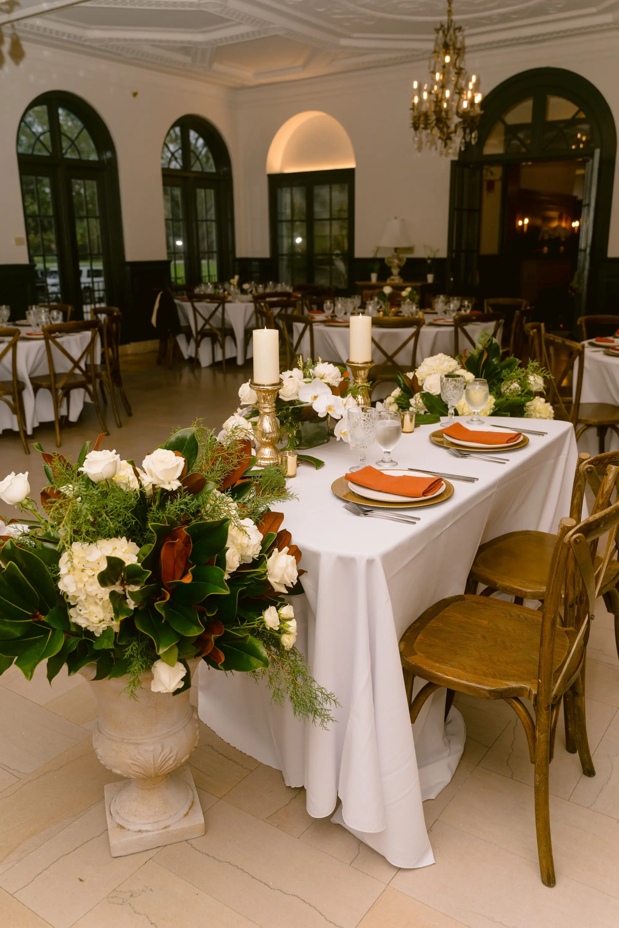 Luxurious Ballroom Wedding Reception | Classic Sweetheart Table with White Orchid Garland with Dark Fall Orange Florals and White Roses Flower Arrangements Inspiration | Gold Chargers with Burnt Orange Napkins and White Menus Ideas | Fall Florida Wedding Inspiration | Historic Academic Venue The New College of Florida