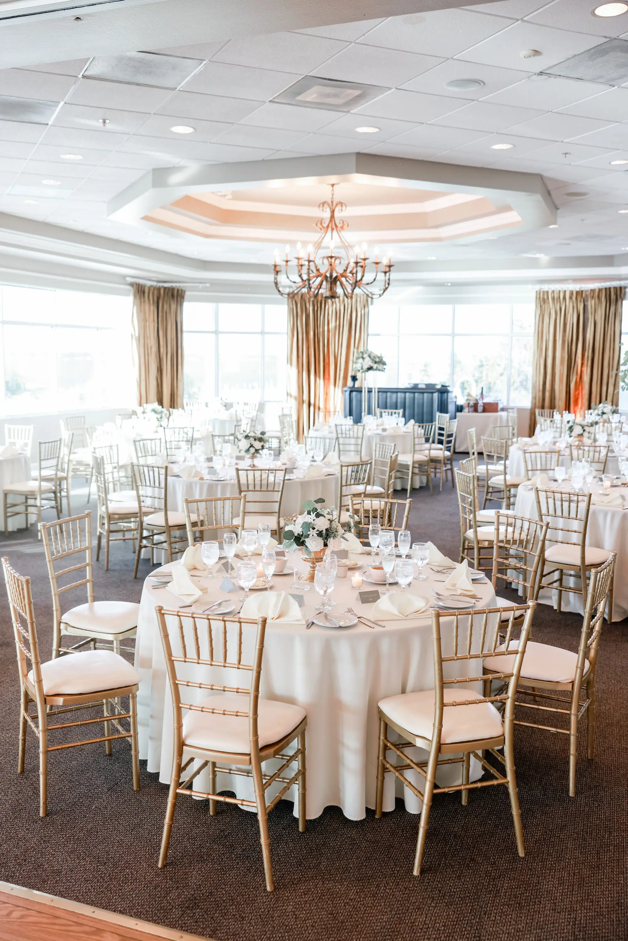Luxurious Ballroom Wedding Reception | Round Wedding Reception Tables with White Linens and Chiavari Chairs | Short Classic Centerpieces with White Roses and Greenery Flower Arrangement Ideas | St Pete Event Venue Isla Del Sol Yacht and Country Club | Tampa Bay Planner Planner Coastal Coordinating