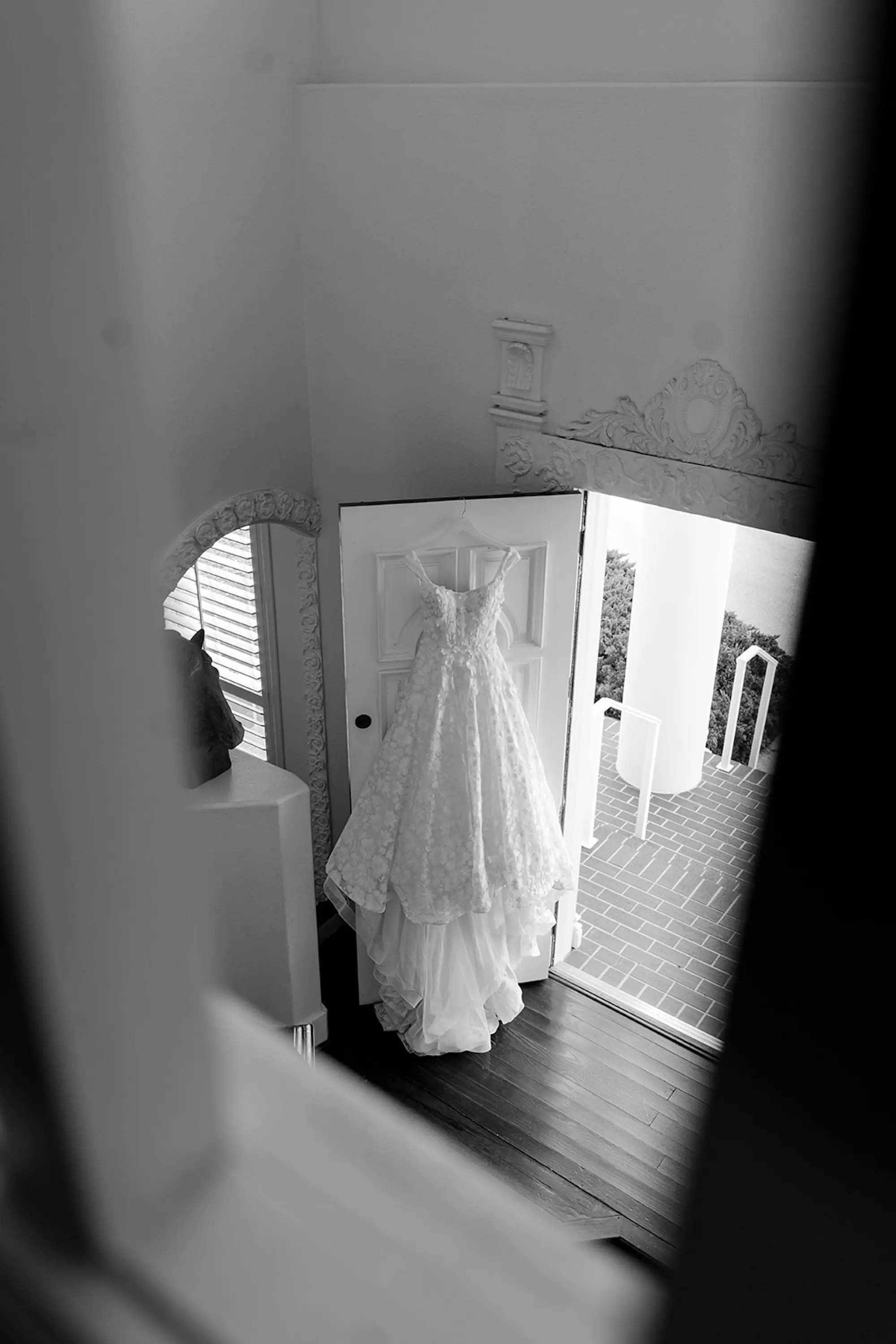 Ivory Ballgown Pronovias Wedding Dress Hanging From Front Door of Ceremony Venue Wedding Portrait