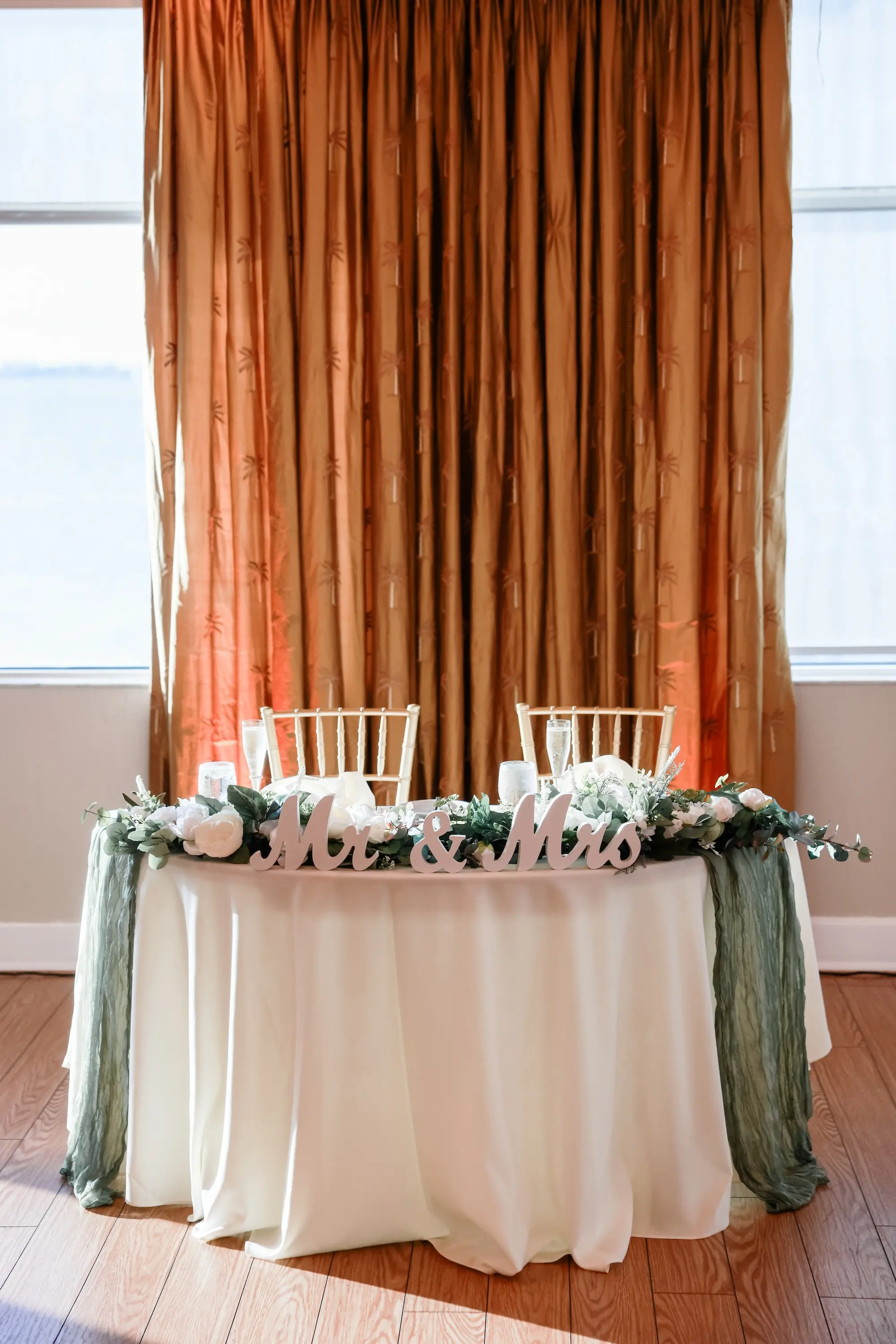 Simple Classic Sweetheart Table with White Linens and White Chairs and Sage Green Linen Table Runner Inspiration | Mr and Mrs Wooden Table Wedding Reception Decor Ideas | Tampa Bay Planner Planner Coastal Coordinating