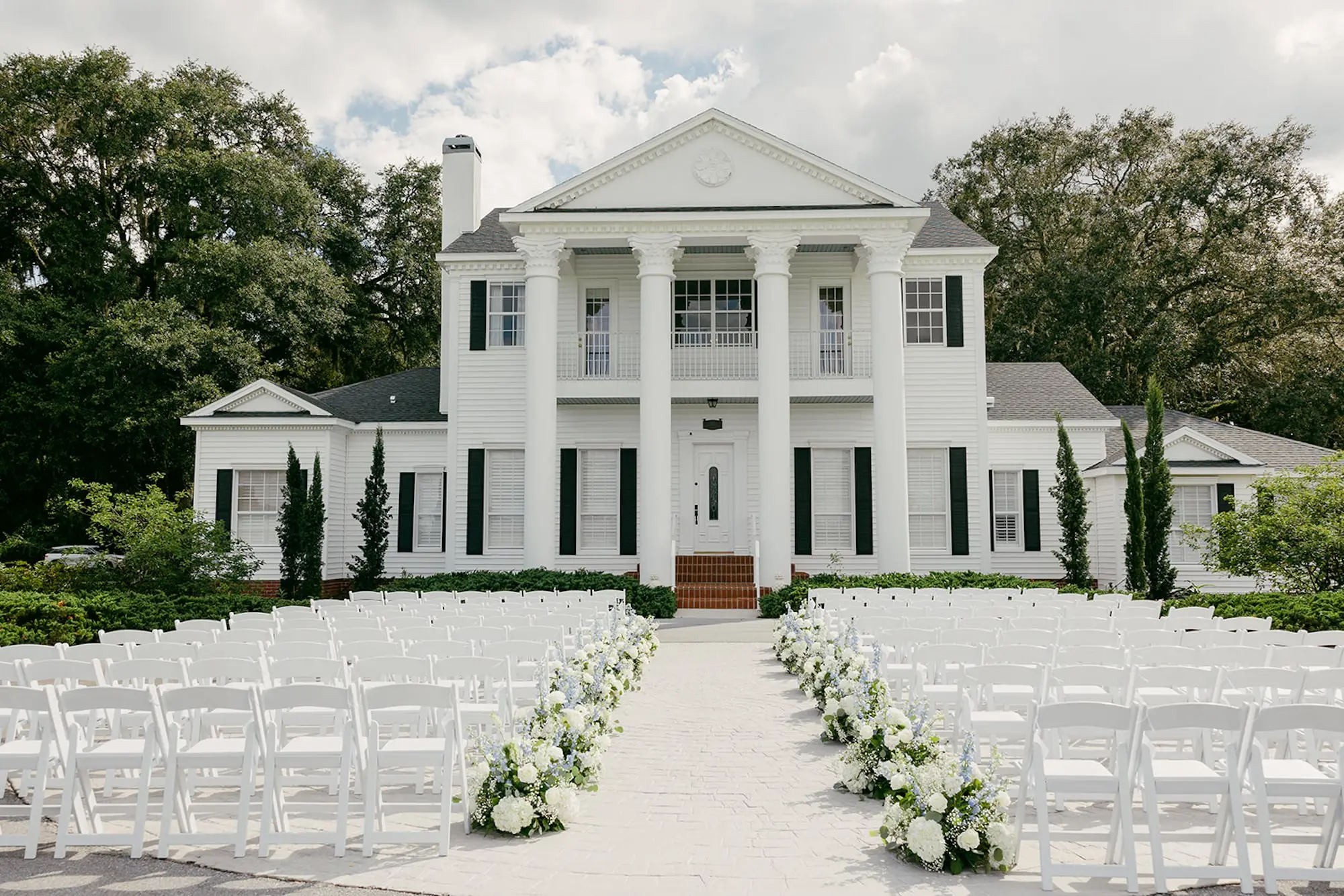 Elegant Outdoor White and Greenery Wedding Ceremony Decor Ideas | White Hydrangeas, Baby's Breath, Light Blue Wisteria and Greenery Flower Arrangement Wedding Ceremony Aisle Decor Inspiration | White Ceremony Chairs Ideas | Tampa Bay Southern Estate Event Venue Legacy Lane Weddings