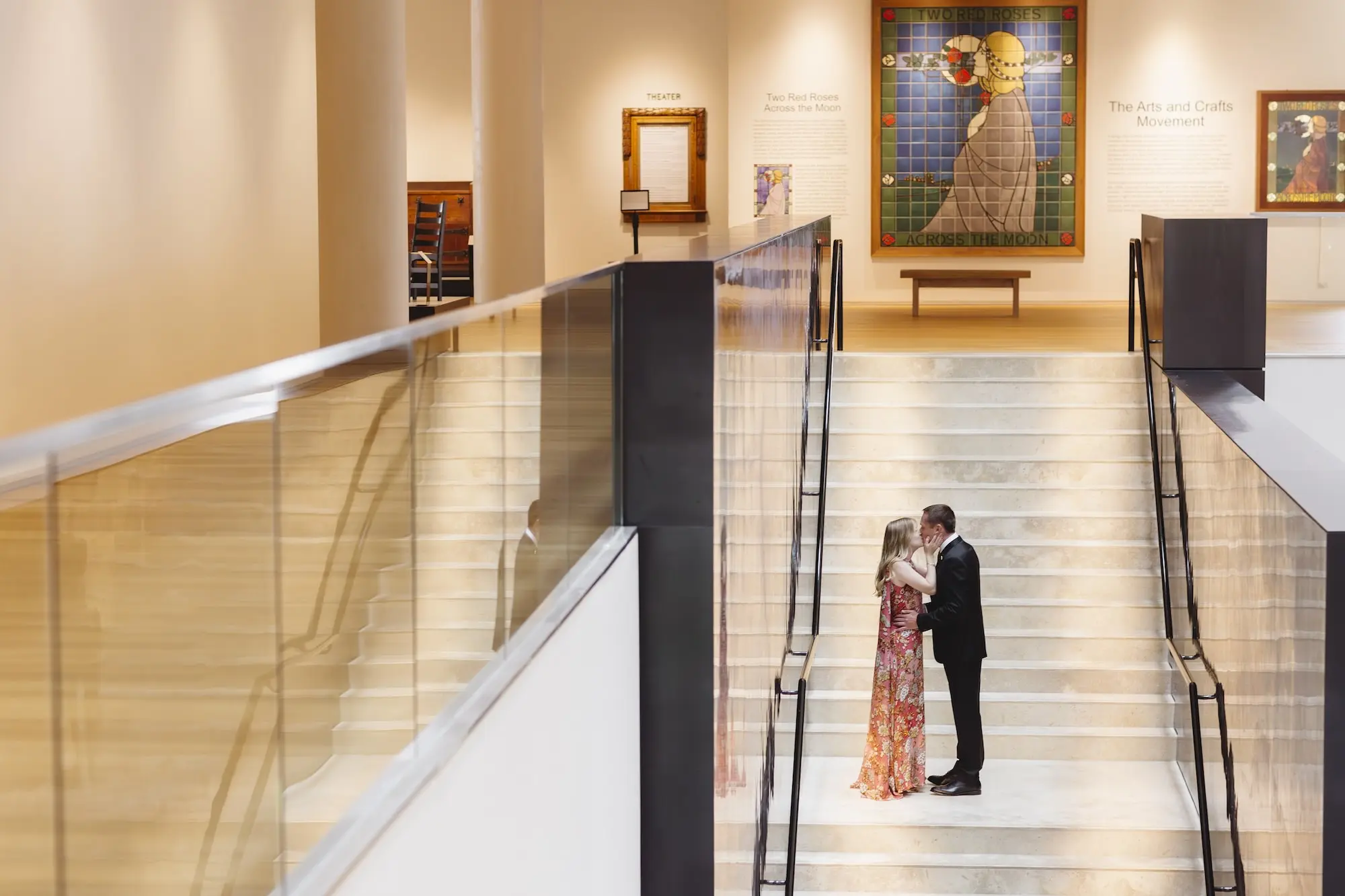 Bride and Groom Wedding Portrait Kissing on Staircase at Museum of the American Arts & Crafts Movement St Pete Wedding Venue | Downtown St Petersburg Wedding Venue Ideas | Rosy Pink Floral Mary Katrantzou Wedding Gown with Dramatic Cape Inspiration
