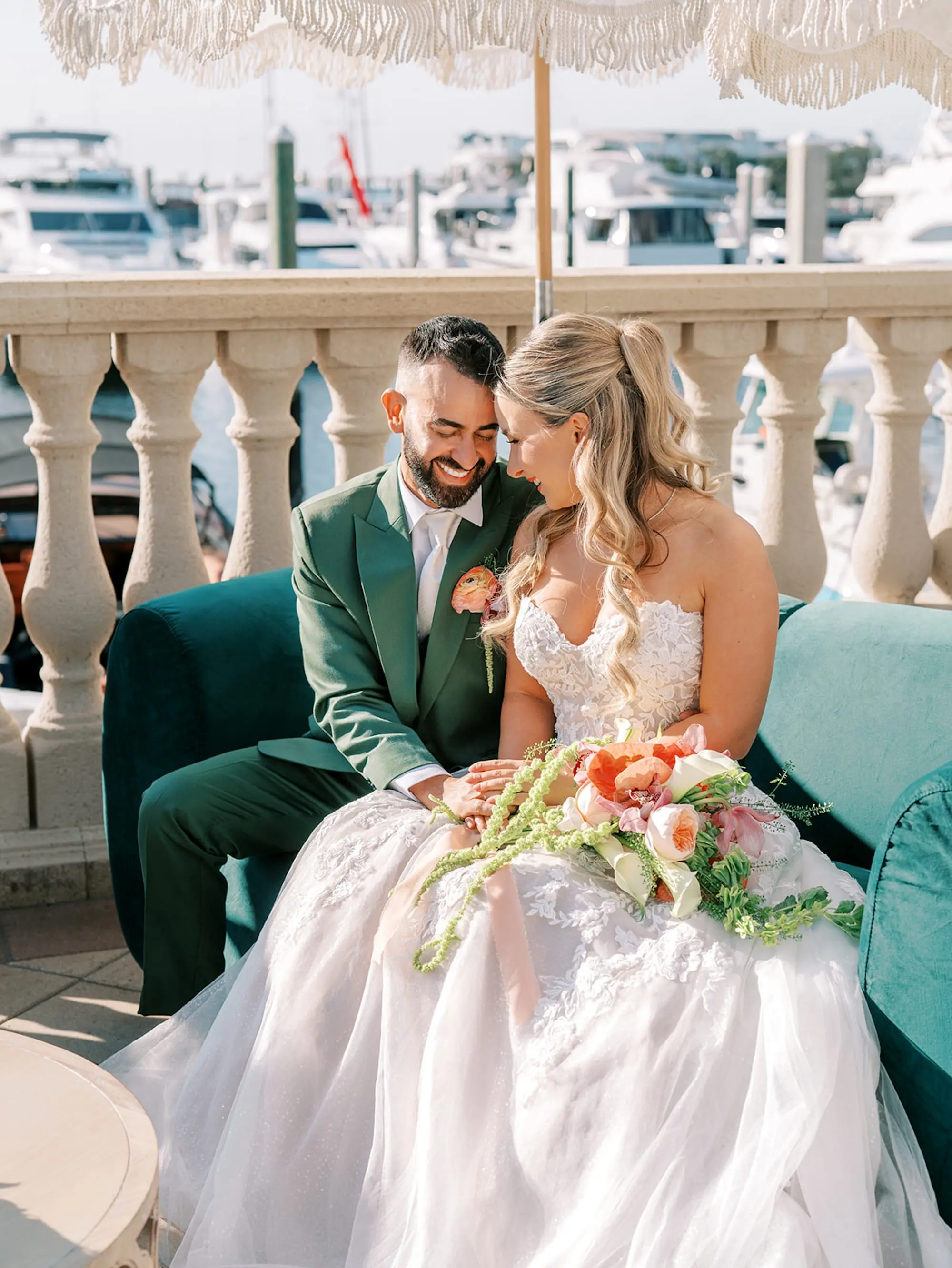Bride and Groom Waterfront Wedding Portrait | South Tampa Outdoor Wedding Venue Westshore Yacht Club | Tropical Coral, Pink and White Orchids, Anthium, Ranunculus Bridal Bouquet Inspiration | Tampa Bay Florist Save The Date Florida | Soft Beach Curls Half Up Half Down Wedding Hair Ideas | Tampa Bay Wedding Hair and Makeup Artist Adore Bridal Hair and Makeup | Groom Green Three-Piece Suit Ideas | South Tampa Photographer Eddy Almaguer Photography | Strapless A-Line Tulle Wedding Gown with Sweetheart Neckline and Floral Lace Inspiration