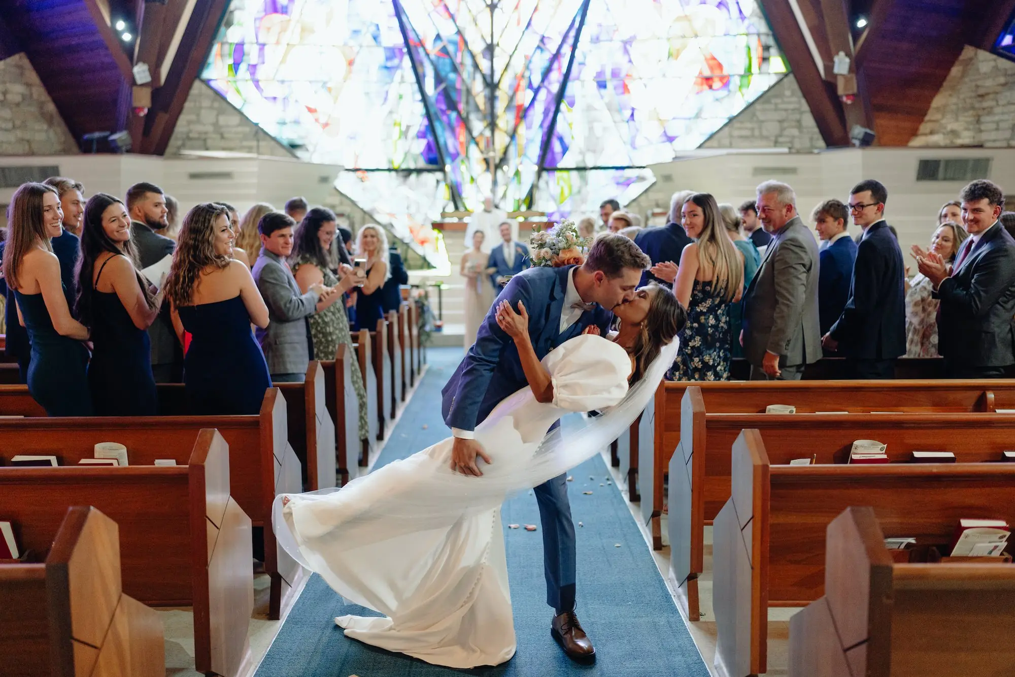 Bride and Groom Kiss Wedding Ceremony Aisle Portrait | Traditional Church Wedding Venue St Petersburg Grace Lutheran Church | Planner Wilder Mind Events | St Pete Photographer Videographer J&S Media