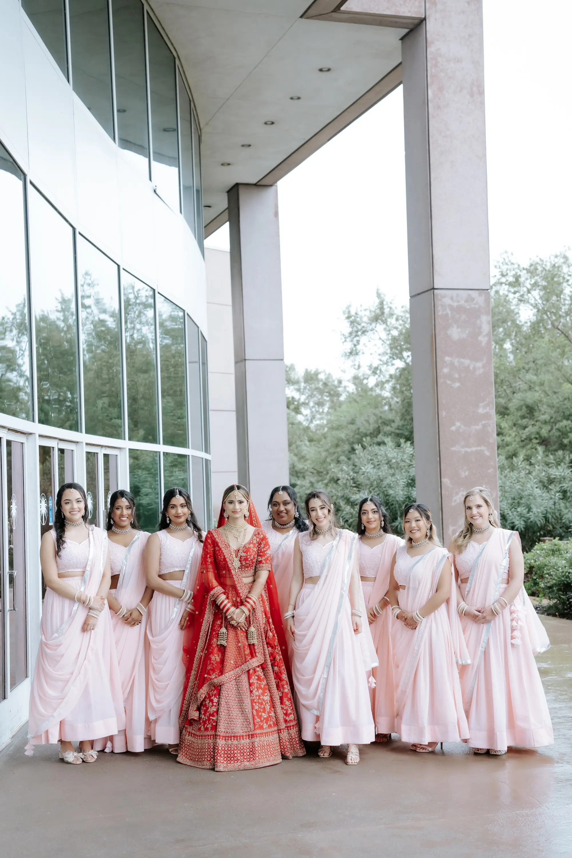 Bride in Traditional Indian Red Lehenga with Intricate Gold Embroidery Wedding Dress Ideas | Pink Bridesmaid Dress Inspiration | Red Matching Dupatta Ideas | Pink Saris Inspiration