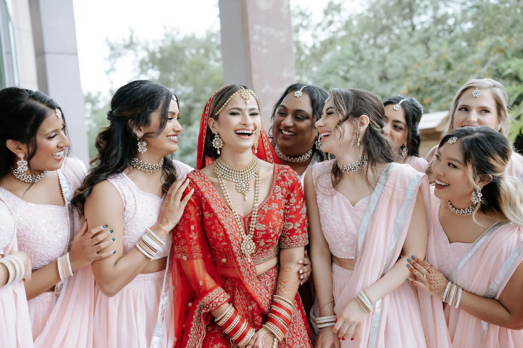 Bride in Traditional Indian Red Lehenga with Intricate Gold Embroidery Wedding Dress Ideas | Pink Bridesmaid Dress Inspiration | Red Matching Dupatta Ideas | Pink Saris Inspiration