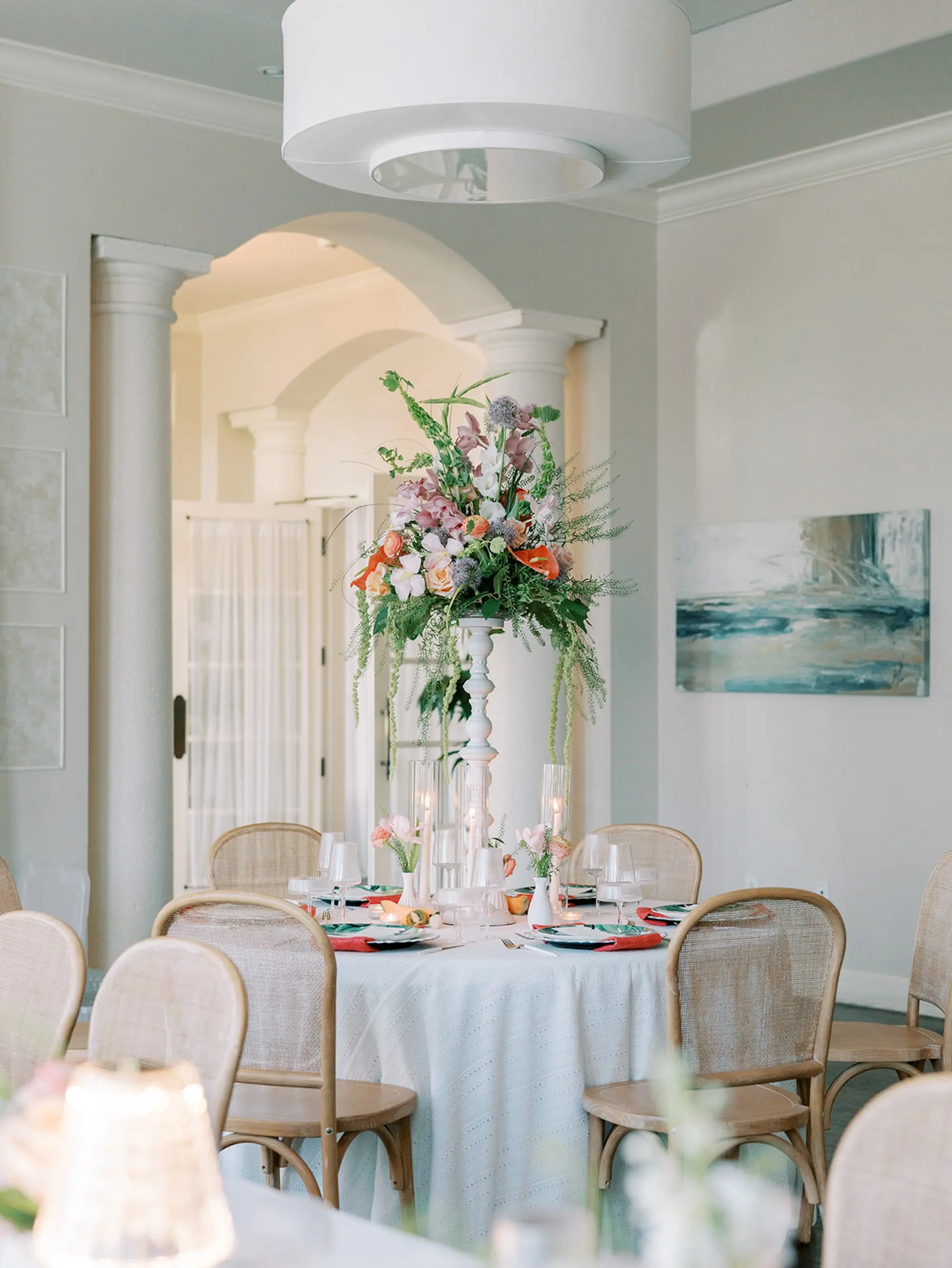 Luxurious Old Florida Ballroom Wedding Reception Portrait | Long and Round Wedding Reception Tables with Wicker Chairs with White Textured Linens with Bud Vases and Romantic Tea Candles Reception Decor Inspiration | Tropical Coral, Pink and White Orchids, Anthium, Ranunculus Reception Centerpiece Inspiration | Vibrant Fruit Dragon Fruit, Kiwi, Melon Table Decor Ideas | Tampa Bay Florist Save The Date Florida | Central Florida Event Planner MDP Events | Tampa Bay Over The Top Rental Linens | Wedding Venue Westshore Yacht Club