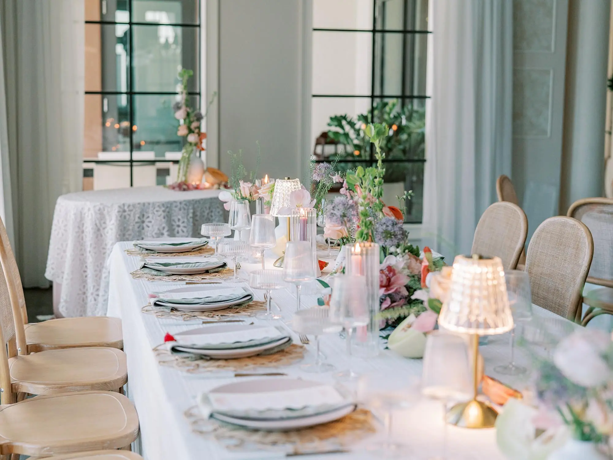 Luxurious Old Florida Ballroom Wedding Reception Portrait | Long and Round Wedding Reception Tables with Wicker Chairs with White Textured Linens with Bud Vases and Romantic Tea Candles and Southern Whimsical Gold Lamps Reception Decor Inspiration | Tropical Coral, Pink and White Orchids, Anthium, Ranunculus Reception Centerpiece Inspiration | Vibrant Fruit Dragon Fruit, Kiwi, Melon Table Decor Ideas | Boho Wicker Chargers with Modern Glassware Inspiration | Tampa Bay Florist Save The Date Florida | Central Florida Event Planner MDP Events | Tampa Bay Over The Top Rental Linens | Wedding Venue Westshore Yacht Club