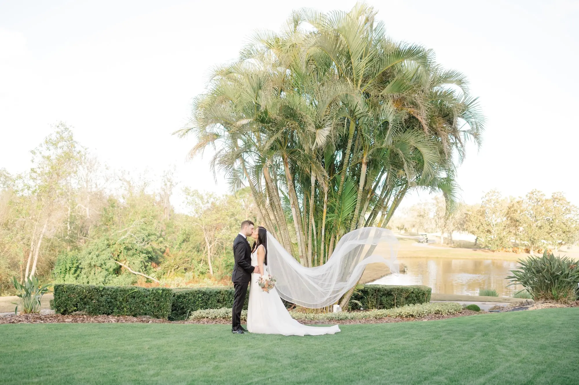 36Romantic Pastel and Navy Sarasota Wedding Inspiration Lakewood Ranch Country Club jpg - Timeless Gold and Green Sarasota Wedding | Lakewood Ranch Golf & Country Club Bride and Groom Kssing on Golf Course Country Club with Veil Flowing Wedding Portrait | Lakefront Country Club Estate Wedding Ceremony Venue Ideas | Susan Elizabeth Weddings Tampa Wedding Photographer | Sarasota Wedding Venue Lakewood Ranch Golf and Country Club