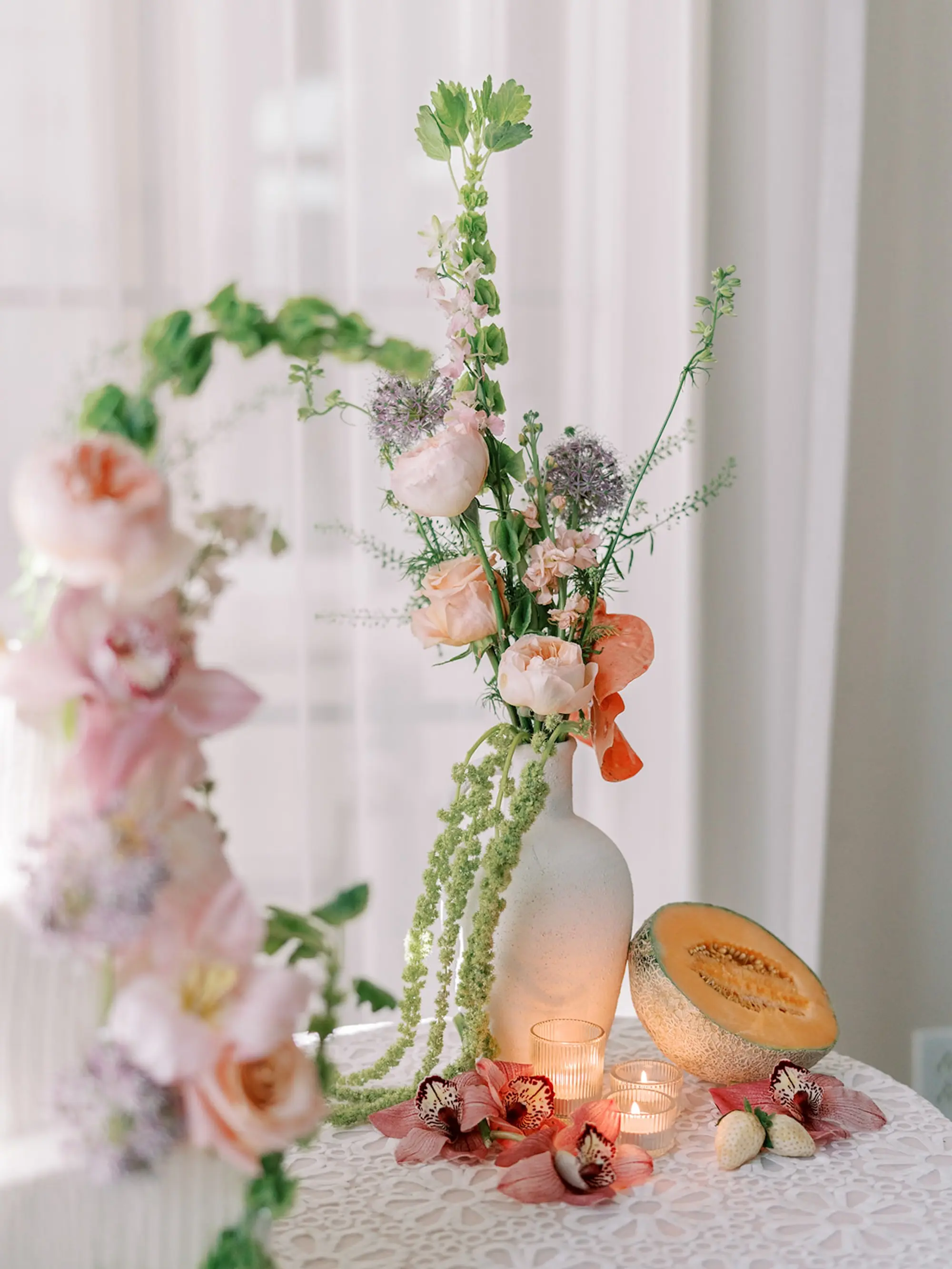 38Elegant Pastel Tropical Wedding Inspriation jpg - “Best Of” 2025: Wedding Receptions Part 2 Wedding Reception Tables with White Daisy Textured Linens and White Vases and Romantic Tea Candles Reception Decor Inspiration | Tropical Coral, Pink and White Orchids, Anthium, Ranunculus Reception Centerpiece Inspiration | Vibrant Fruit Dragon Fruit, Kiwi, Melon Table Decor Ideas | Tampa Bay Florist Save The Date Florida | Central Florida Event Planner MDP Events | Tampa Bay Over The Top Rental Linens