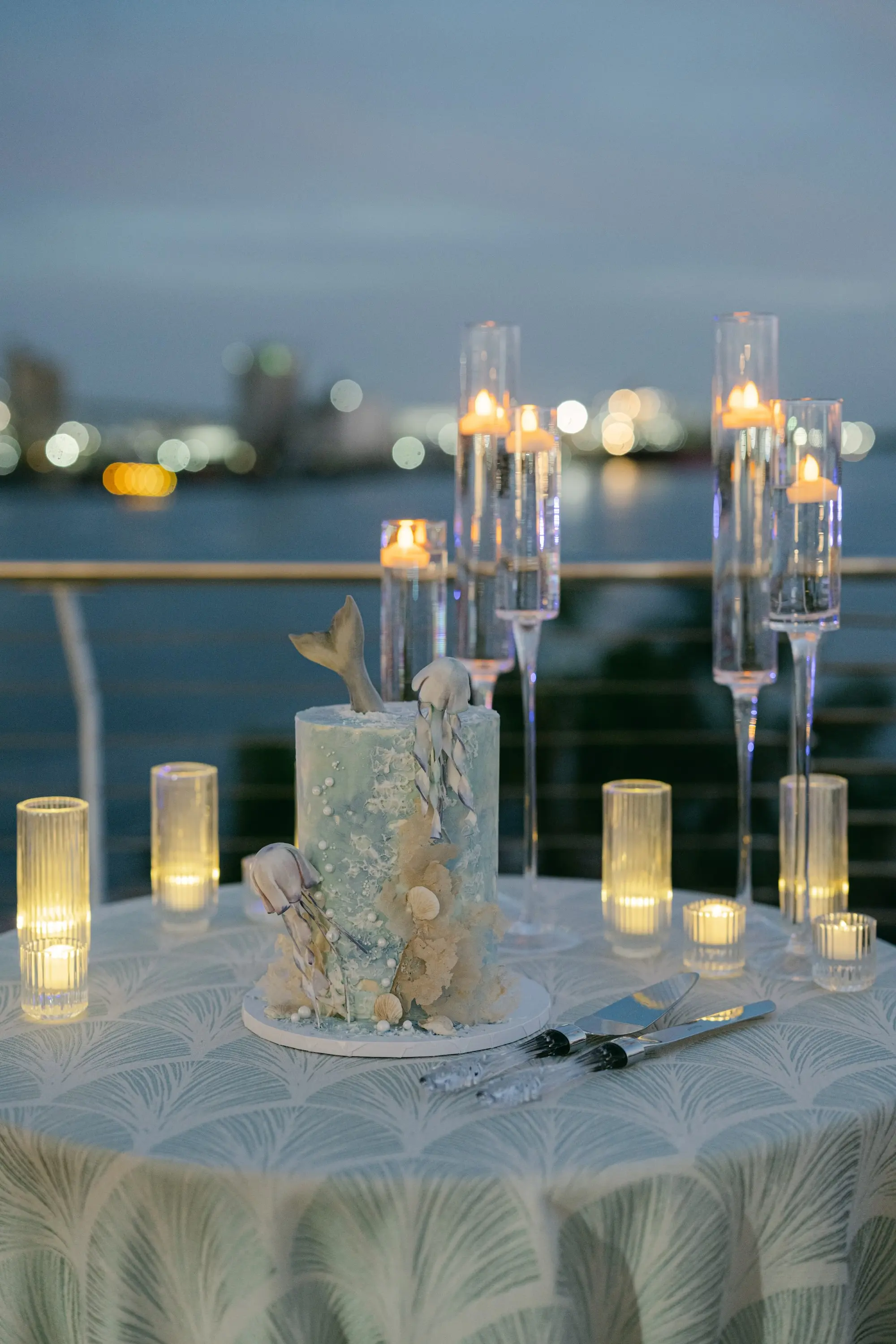 Single-Tiered Round Blue Ocean Inspired Wedding Cake Ideas | Palm Detailed Linens with Romantic Tea Candles and Floating Tea Candles Wedding Reception Decor Inspiration