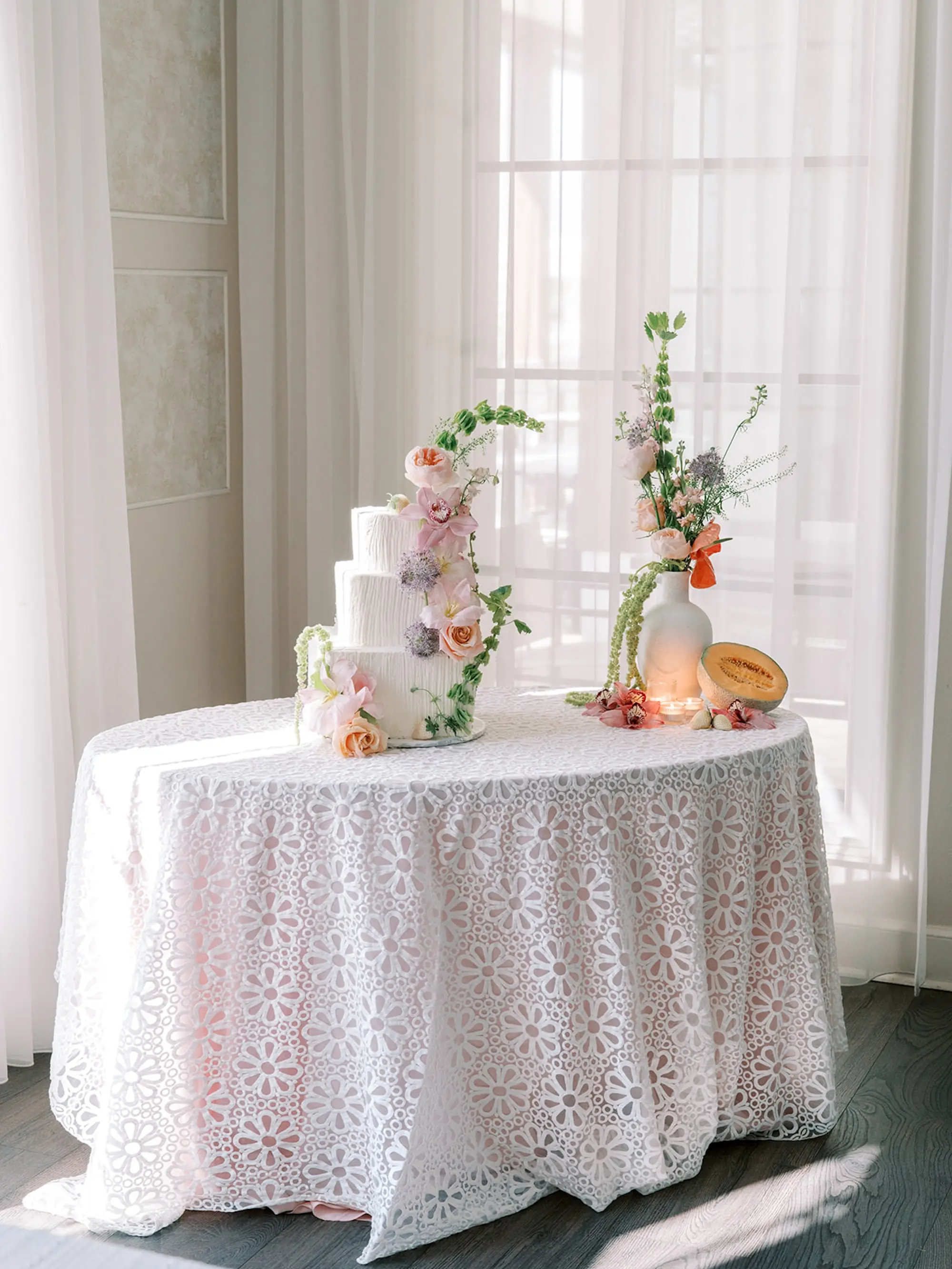 39Elegant Pastel Tropical Wedding Inspriation jpg - “Best Of” 2025: Wedding Receptions Part 2 White Three-Tiered Cake with Tropical Floral Decor on White Daisy Detailed Linens | Long and Round Wedding Reception Tables with Wicker Chairs with White Textured Linens with Bud Vases and Romantic Tea Candles Reception Decor Inspiration | Tropical Coral, Pink and White Orchids, Anthium, Ranunculus Reception Centerpiece Inspiration | Vibrant Fruit Dragon Fruit, Kiwi, Melon Table Decor Ideas | Tampa Bay Florist Save The Date Florida | Central Florida Event Planner MDP Events | Tampa Bay Over The Top Rental Linens | Tampa Bay Bakery Faba's Sweetshop