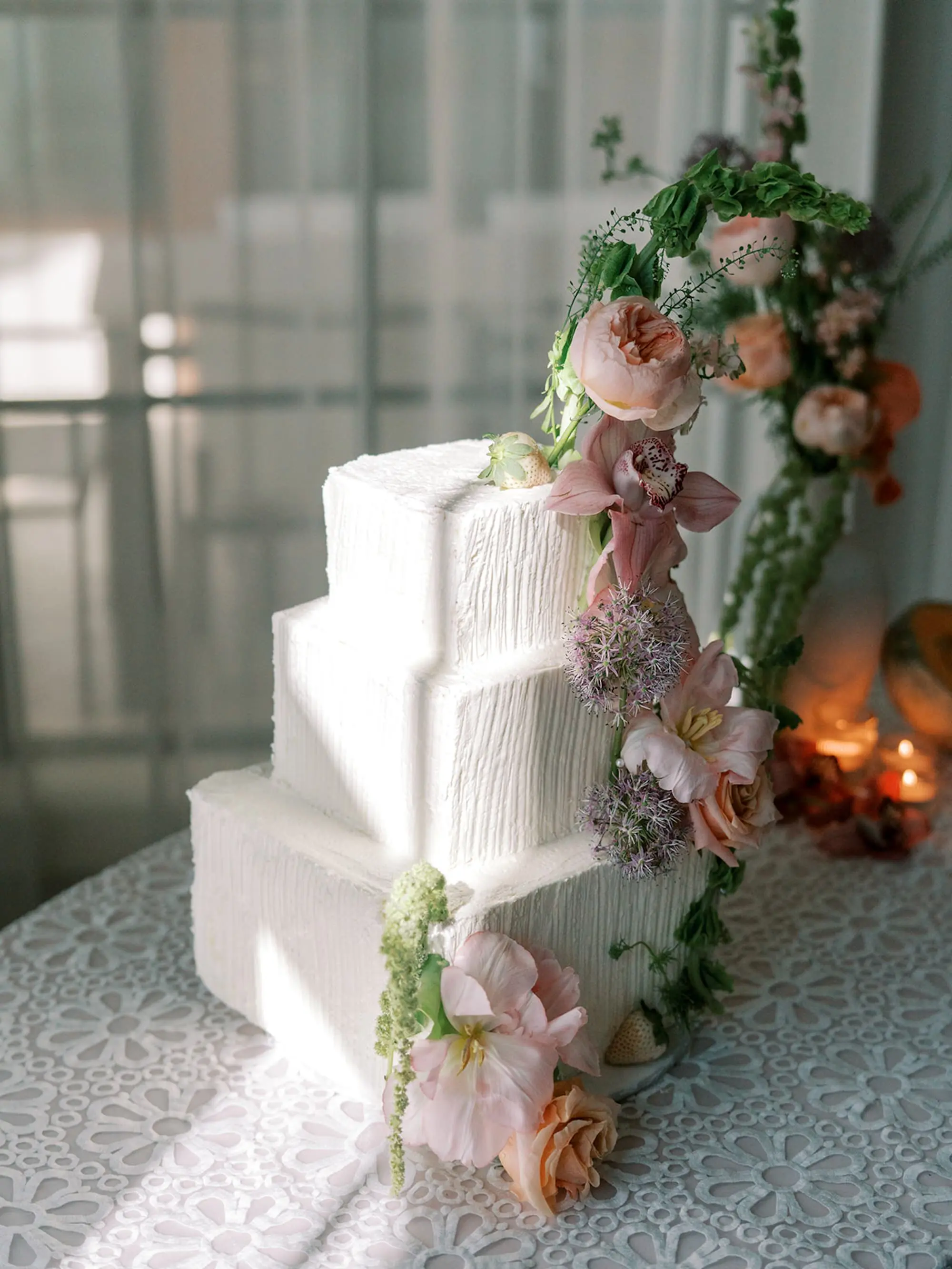 40Elegant Pastel Tropical Wedding Inspriation jpg - “Best Of” 2025: Wedding Receptions Part 2 White Three-Tiered Cake with Tropical Floral Decor on White Daisy Detailed Linens | Long and Round Wedding Reception Tables with Wicker Chairs with White Textured Linens with Bud Vases and Romantic Tea Candles Reception Decor Inspiration | Tropical Coral, Pink and White Orchids, Anthium, Ranunculus Reception Centerpiece Inspiration | Vibrant Fruit Dragon Fruit, Kiwi, Melon Table Decor Ideas | Tampa Bay Florist Save The Date Florida | Central Florida Event Planner MDP Events | Tampa Bay Over The Top Rental Linens | Tampa Bay Bakery Faba's Sweetshop