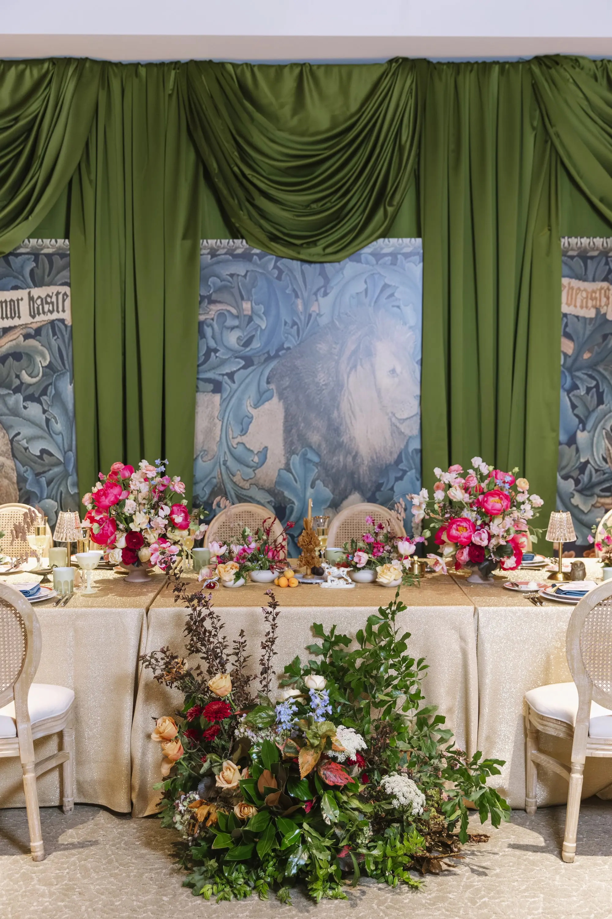 Long Table with Gold Linens and Natural Wicker King Louis Chairs with Bright Pink Peonies and Blue, Burgundy, Blush, and Yellow Floral Centerpieces and Oaxaca Candles Wedding Reception Table Decor Inspiration | Eclectic Wedding Reception Decor Ideas | Green Linen Wall Draping Inspiration | St Pete Florist Bruce Wayne Florals | Florida Luxury Planner Parties A'La Carte