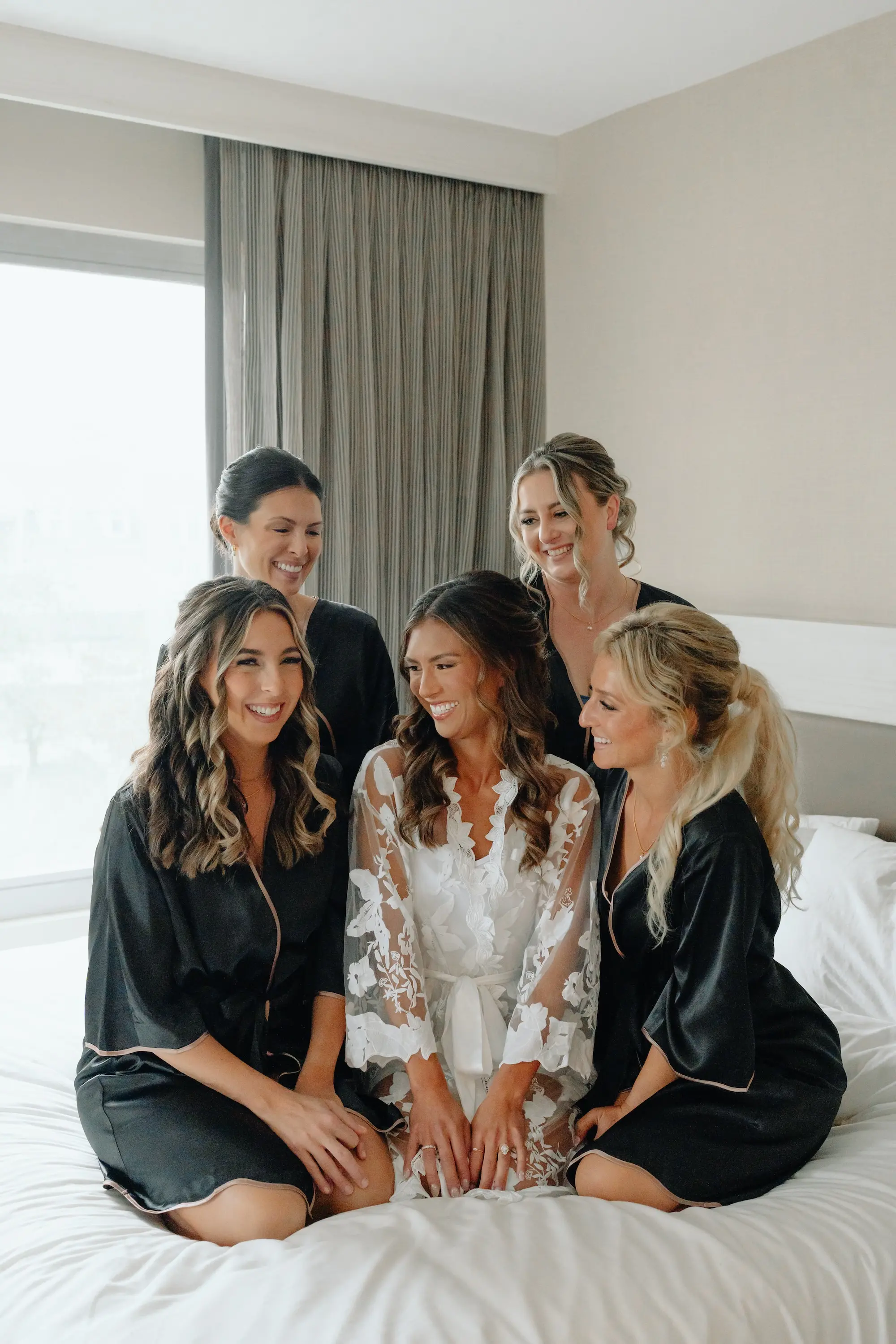 Bride and Bridesmaids Getting Ready in Matching Black Robe Wedding Portrait | Half Up Half Down Soft Face Framing Curls Wedding Bridal Hair Inspiration | Tampa Bay Wedding Hair and Makeup Artist Adore Bridal Hair and Makeup | Florida Photographer and Videographer J&S Media Wedding Films & Photo