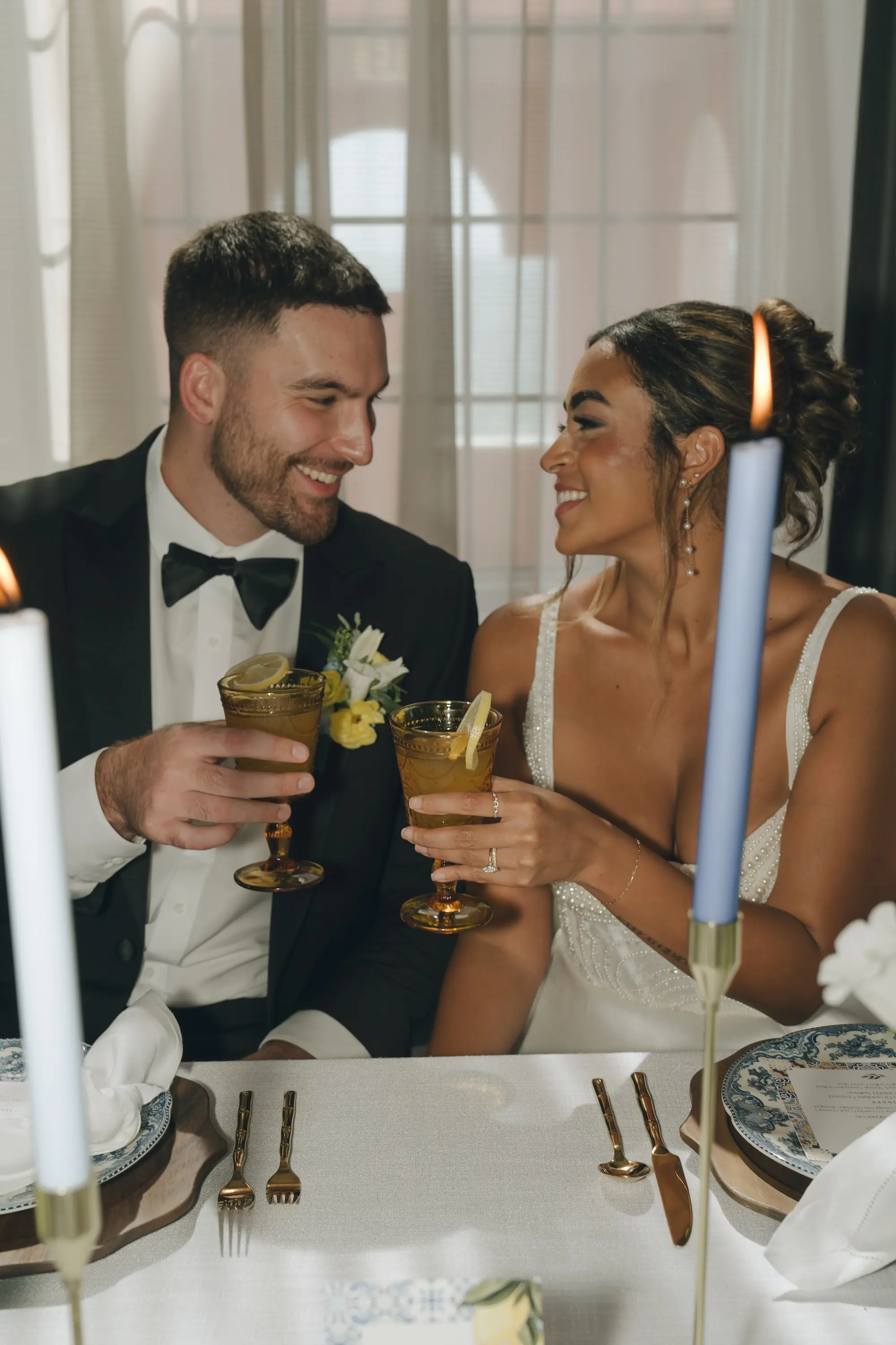 Bride and Groom Toasting Wedding Portrait in Luxurious Ballroom | Wedding Venue Don CeSar | Romantic Shades of Blue Taper Candles on White Linen with Gold Flatware and Wooden Chargers with Patterned China Inspiration | Kate Ryan Event Rentals | Tampa Bay Over The Top Rental Linens | Tampa Bay Planner Planner Coastal Coordinating | Photographer Amber Yonker Photography