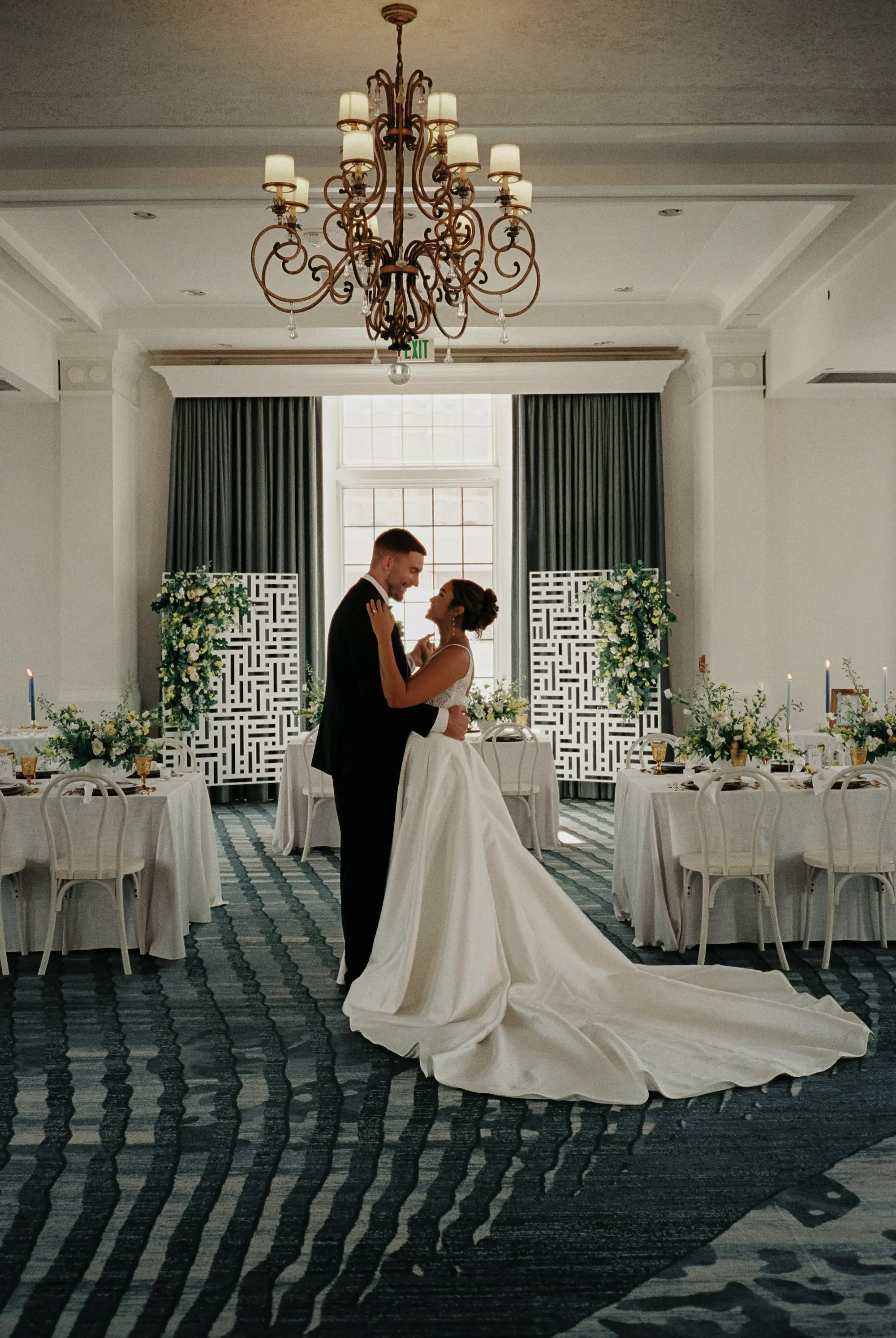 Bride and Groom Wedding Portrait in Luxurious Ballroom | Wedding Venue Don CeSar | Ballgown Wedding Dress Boutique Truly Forever Bridal Tampa | White Linens with Classic White Chairs with Romantic Taper Candlelight and White Roses with Greenery Wedding Reception Decor Inspiration | Kate Ryan Event Rentals | Tampa Bay Over The Top Rental Linens | Tampa Bay Planner Planner Coastal Coordinating