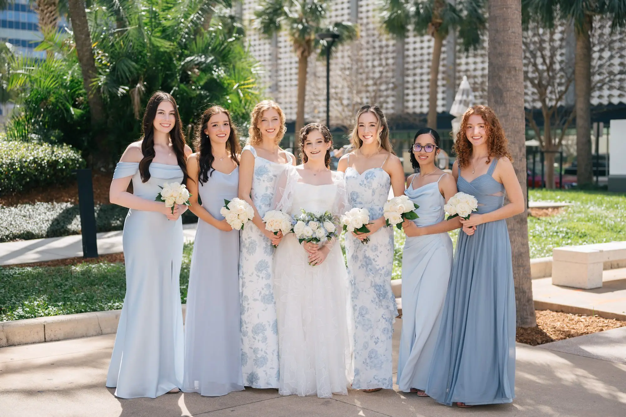 Bride and Bridesmaids Downtown Tampa Outdoor Wedding Portrait | Mismatched Different Light Blue Bridesmaid Dresses Inspiration | Classic White Roses Bouquet Ideas