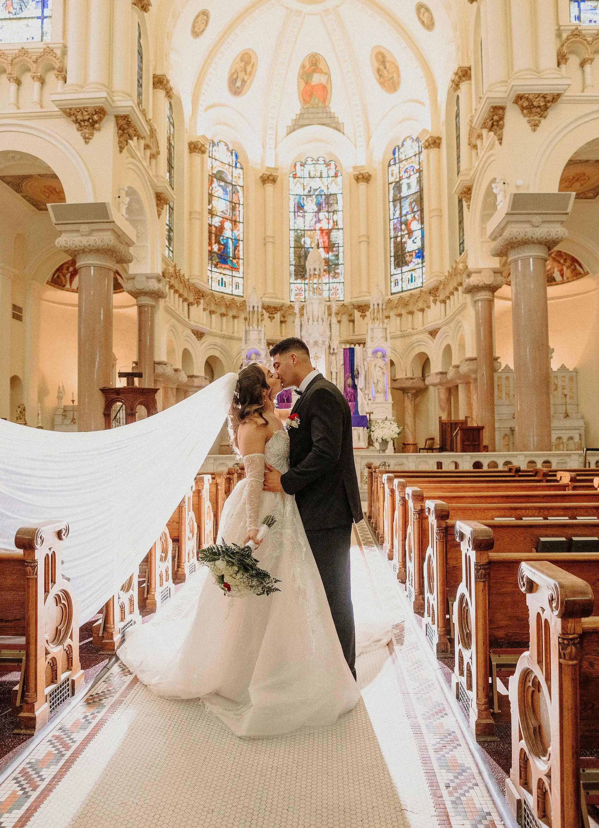 15Classic Gold Italian Inspired Wedding Ideas Tampa Venue Sacred Heart Church - Classic, Gold Tampa Wedding | The Italian Club of Tampa Bride and Groom Kissing Wedding Ceremony Aisle Portrait | Traditional Cathedral Length Chiffon Veil Ideas | Sacred Heart Catholic Church Wedding Ceremony Venue | Traditional Catholic Wedding Ceremony Event Ideas | Tampa Bay Photographer Sabrina Autumn Photography
