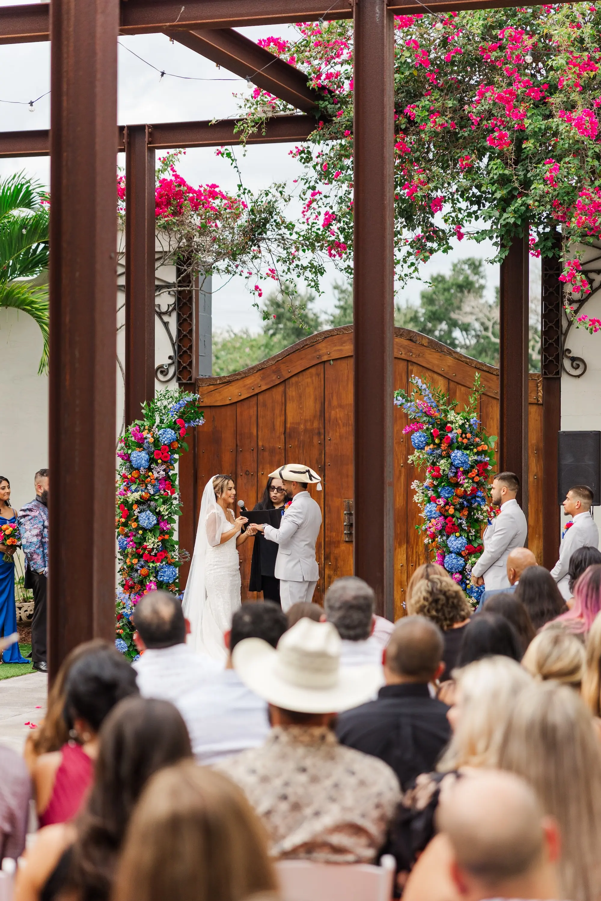 17Vibrant Blue Mexican Wedding Ideas - Blue Mexican-Inspired Winter Haven Wedding | Venue 650 Bride and Groom Wedding Ceremony Vow Exchange Wedding Portrait | Semi Circle Alter Arches Decor of Bright Pink, Orange and Blue Flowers with Greenery Inspiration | Tampa Bay Photographer Mary Anna Photography