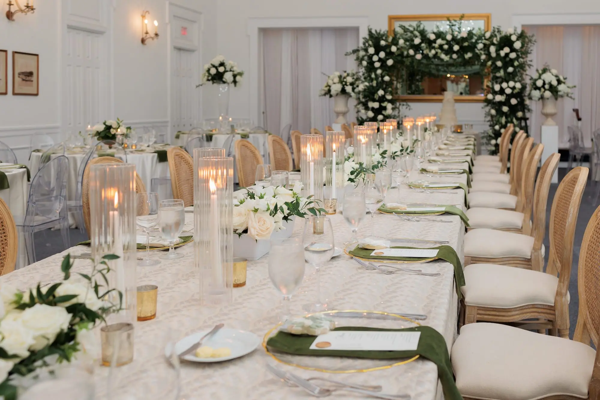 Timeless Ballroom Wedding Reception | Southern Wooden Rattan Chairs | Lush Elegant Centerpieces and Decor with White Roses, Greenery Eucalyptus Flower Arrangement Ideas | Soft White Taper Candle Decor Inspiration | White Linens with Gold Rimmed Chargers and Olive Green Napkins Tablescape Ideas | Romantic White Taper Candlelight Decor Inspiration | Tampa Bay Kate Ryan Event Rentals | Florist Save The Date Florida | Planner EventFull Weddings | Tampa Yacht and Country Club