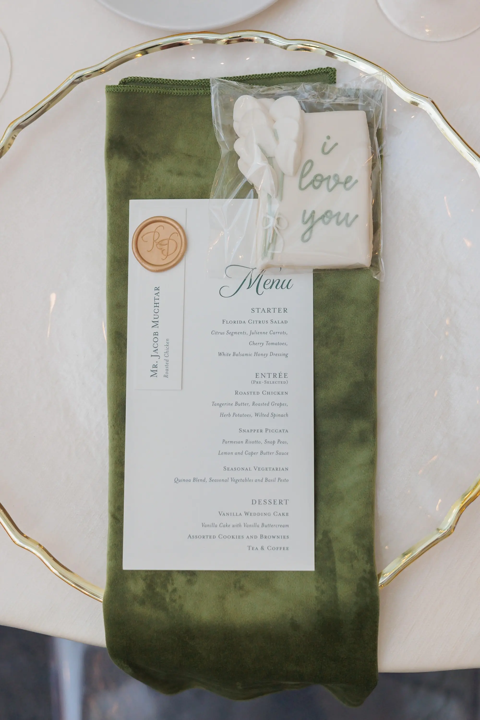 Elegant White and Green Wedding Reception Place Setting Inspiration | Clear Gold Rimmed Charger with Satin Olive Green Napkin Place Setting Inspiration | Wedding Reception Favor Personalized Cookie Ideas | Tampa Bay Kate Ryan Event Rentals | Planner EventFull Weddings