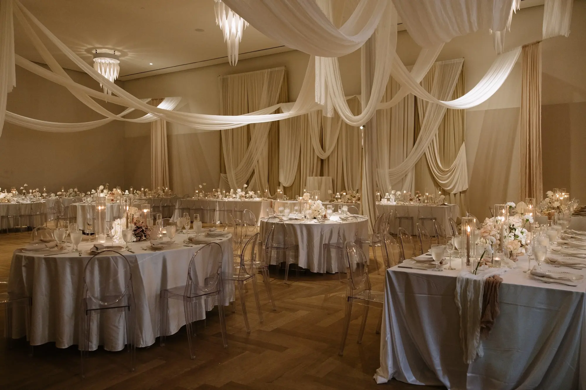 Luxurious Ballroom Wedding Reception | Modern Clear Chairs | Single Stem Centerpieces in Bud Vases with White Flower Arrangement Ideas | Romantic Taper Candles in Vases and Small Gold Table Lamps Decor Inspiration | White Linen Ceiling and Wall Draping Ideas | Tampa Bay Planner EventFull Weddings | Ybor Event Venue Hotel Haya