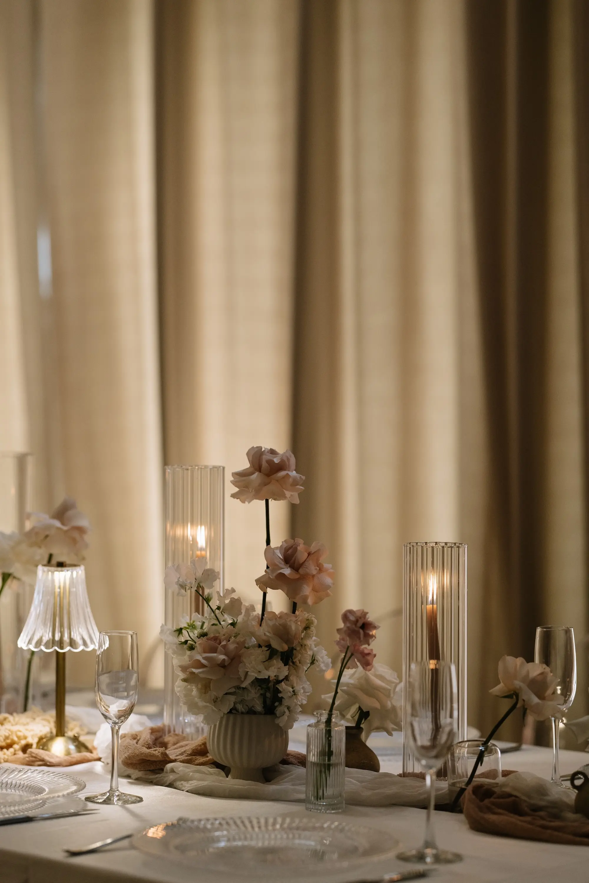 Soft, Romantic Ballroom Wedding Reception Tablescape Inspiration | Ethereal Candlelight Decor Ideas | Single Stem Blush and White in Glass Bud Vase Wedding Reception Table Decor Inspiration | White, Cream, and Soft Gold Wedding Reception Decor Ideas | White Linens with Candles and Small Decorative Table Lamps Inspiration | Tampa Bay Planner EventFull Weddings