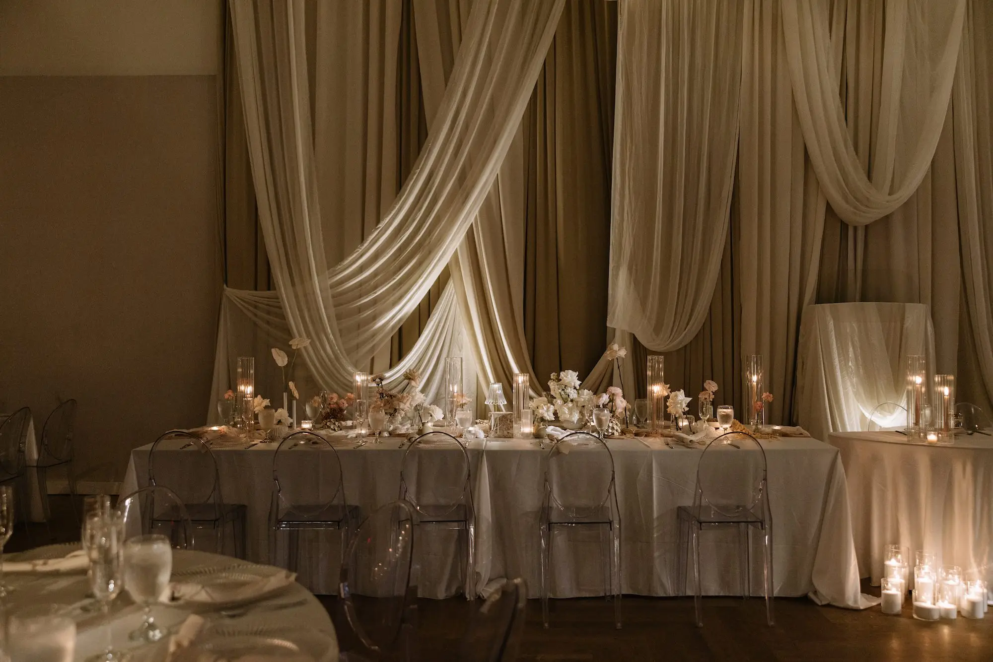 Luxurious Ballroom Wedding Reception | Modern Clear Chairs | Single Stem Centerpieces in Bud Vases with White Flower Arrangement Ideas | Romantic Taper Candles in Vases and Small Gold Table Lamps Decor Inspiration | White Linen Ceiling and Wall Draping Ideas | Tampa Bay Planner EventFull Weddings | Ybor Event Venue Hotel Haya