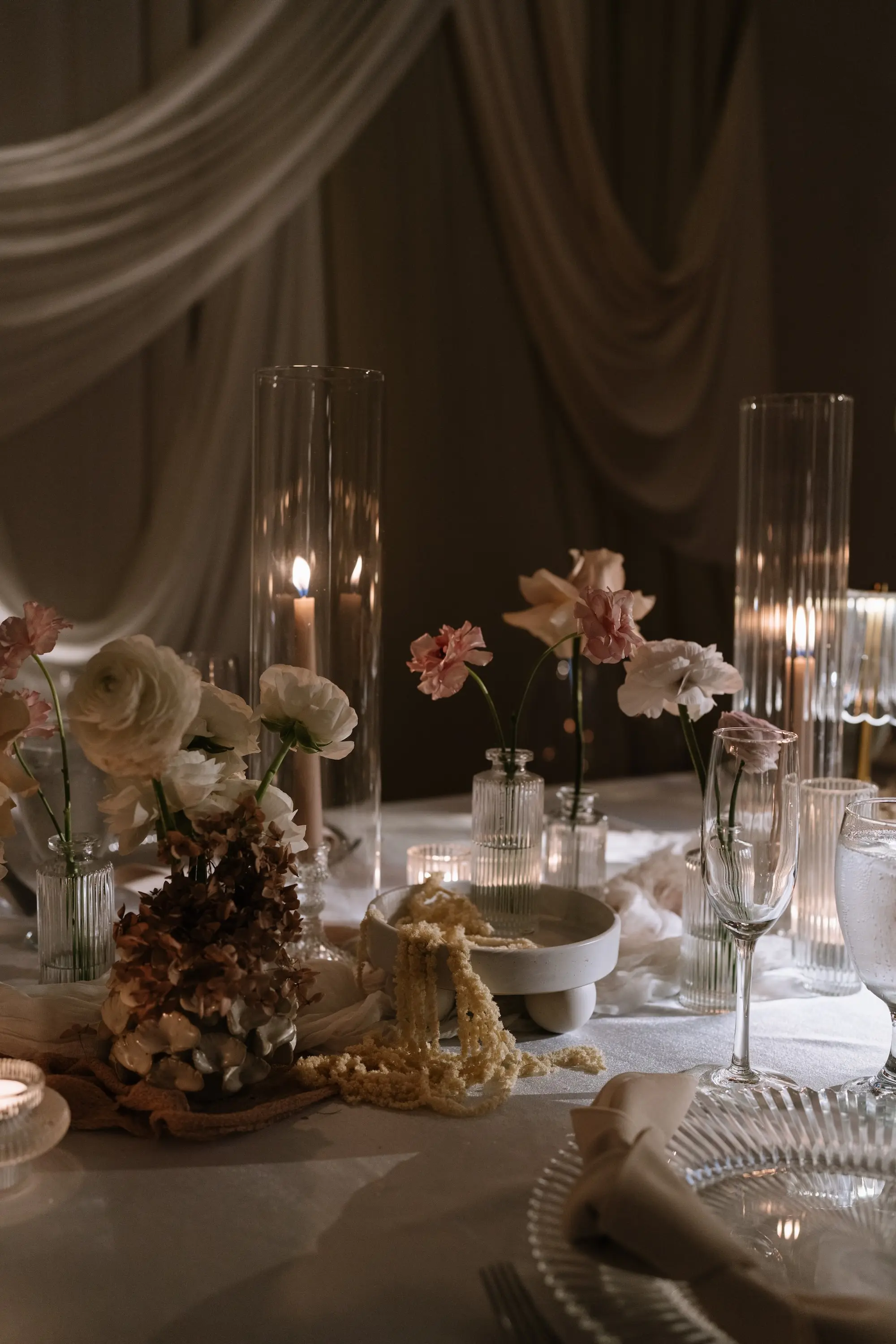 Soft, Romantic Ballroom Wedding Reception Tablescape Inspiration | Ethereal Candlelight Decor Ideas | Single Stem Blush and White Florals in Glass Bud Vase Wedding Reception Table Decor Inspiration | White, Pink, and Peach Peonies Floral Ideas | White Linens with Tall, Clear Glass Cylinder Vases with Taper Candles Inspiration | Tampa Bay Planner EventFull Weddings