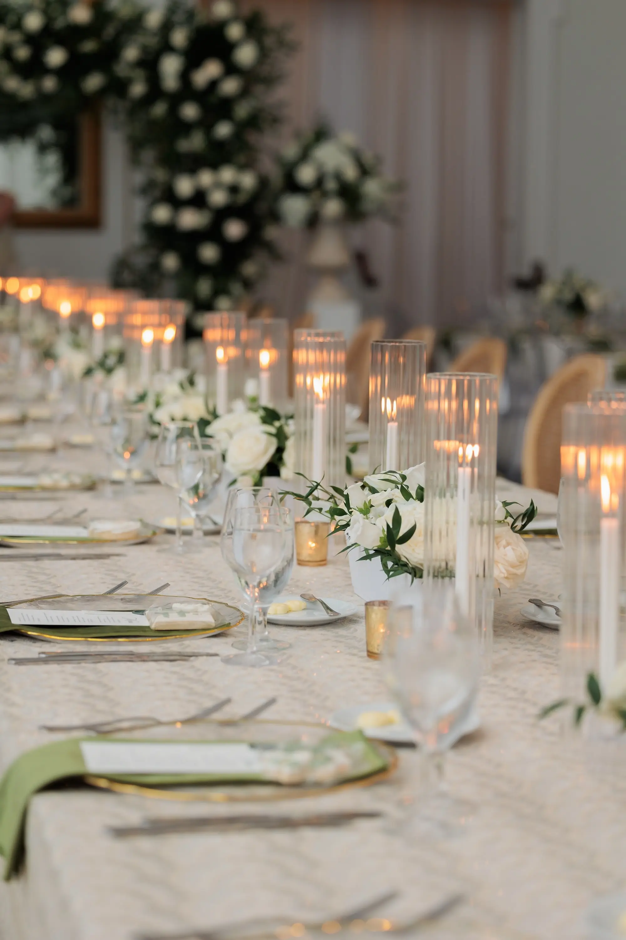Timeless Green, White, and Gold Wedding Reception Centerpiece Decor Ideas | Soft, Romantic Candle Light in White Roses and Eucalyptus Garland Tablescape Decor Ideas | Clear Chargers with Gold Rims and Gold Flatware Tablescape Tampa Bay Kate Ryan Event Rentals | Planner EventFull Weddings