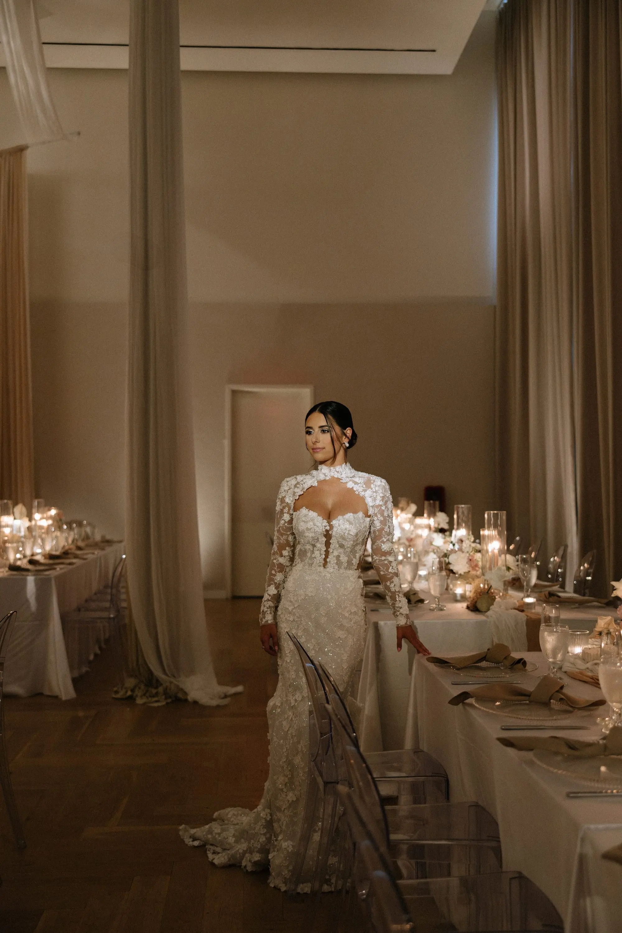 Bride Wedding Reception Portrait | Intricate Floral Lace Fitted Silhouette Liz Young Wedding Gown with Long Sleeves, High Neckline with a Bolero-Style Lace Overlay Inspiration | Luxurious Ballroom Wedding Reception | Modern Clear Chairs | Romantic Candlelight Decor Ideas | Tampa Bay Planner EventFull Weddings | Ybor Event Venue Hotel Haya