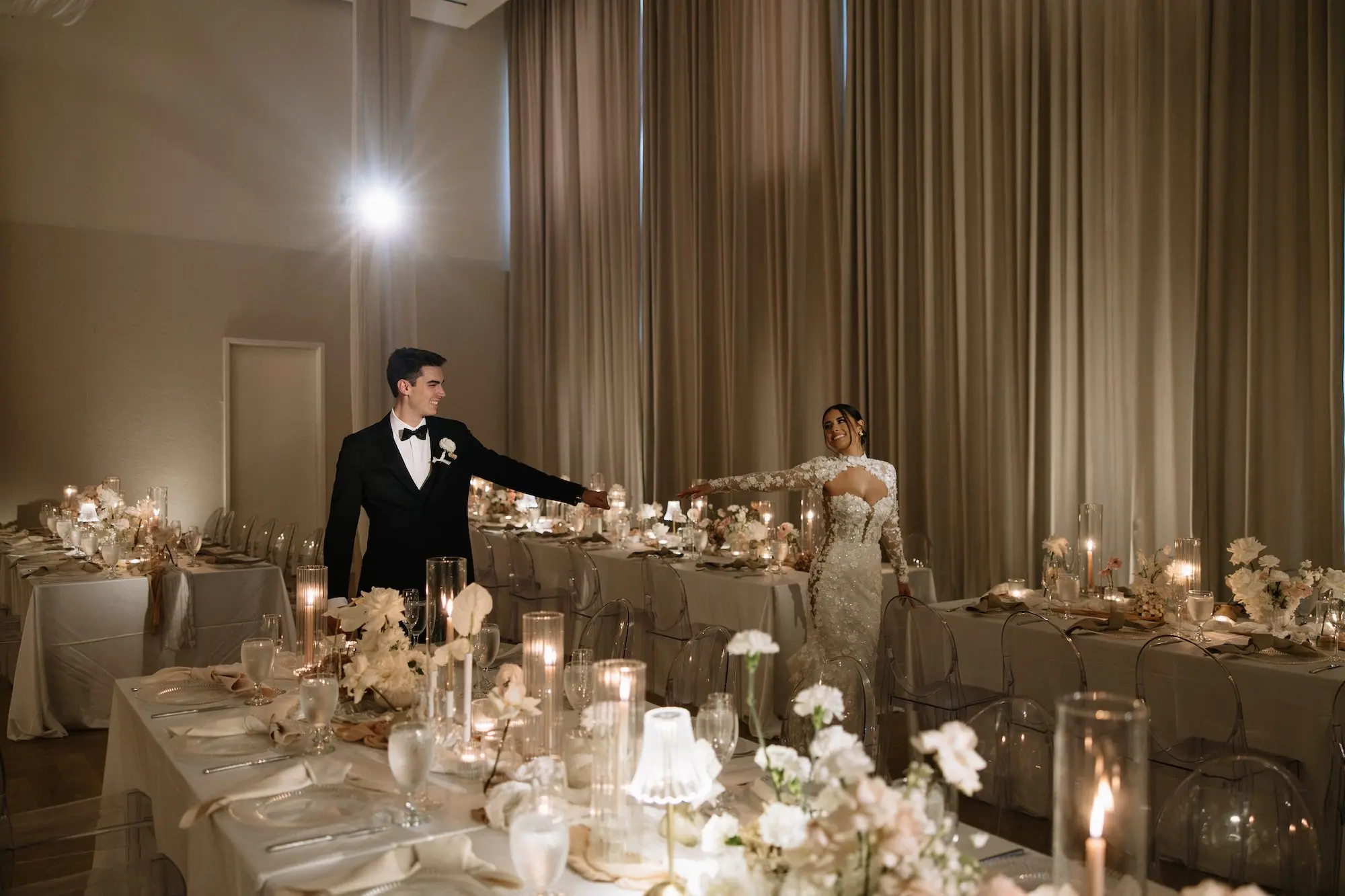 Bride and Groom Wedding Reception Portrait | Luxurious Ballroom Wedding Reception | Modern Clear Chairs | Short Lush Centerpieces with White Flower Arrangement Ideas | Romantic Taper Candles in Vases and Small Gold Table Lamps Decor Inspiration | Tampa Bay Planner EventFull Weddings | Ybor Event Venue Hotel Haya