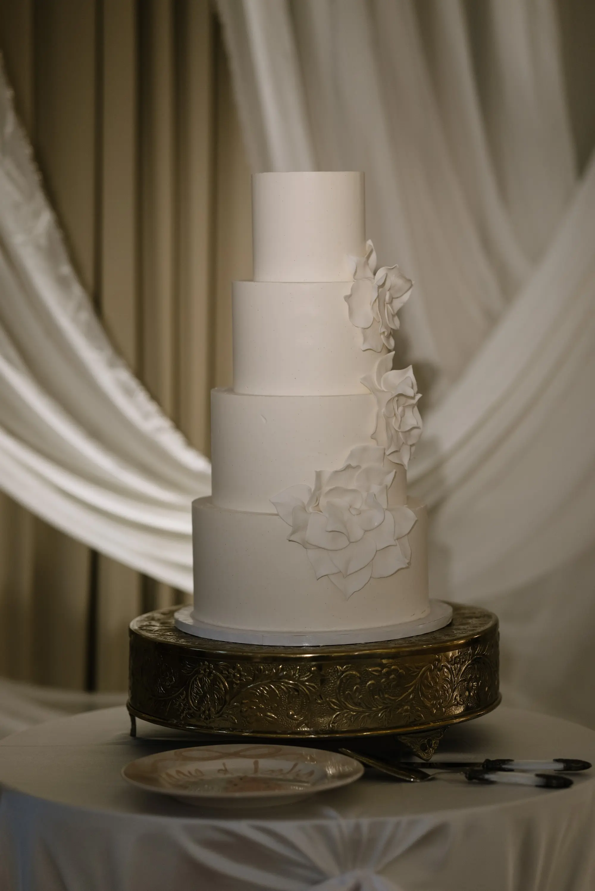 Four Tier White Wedding Cake with Monochromatic White Frosting Florals on Gold Stand Inspiration