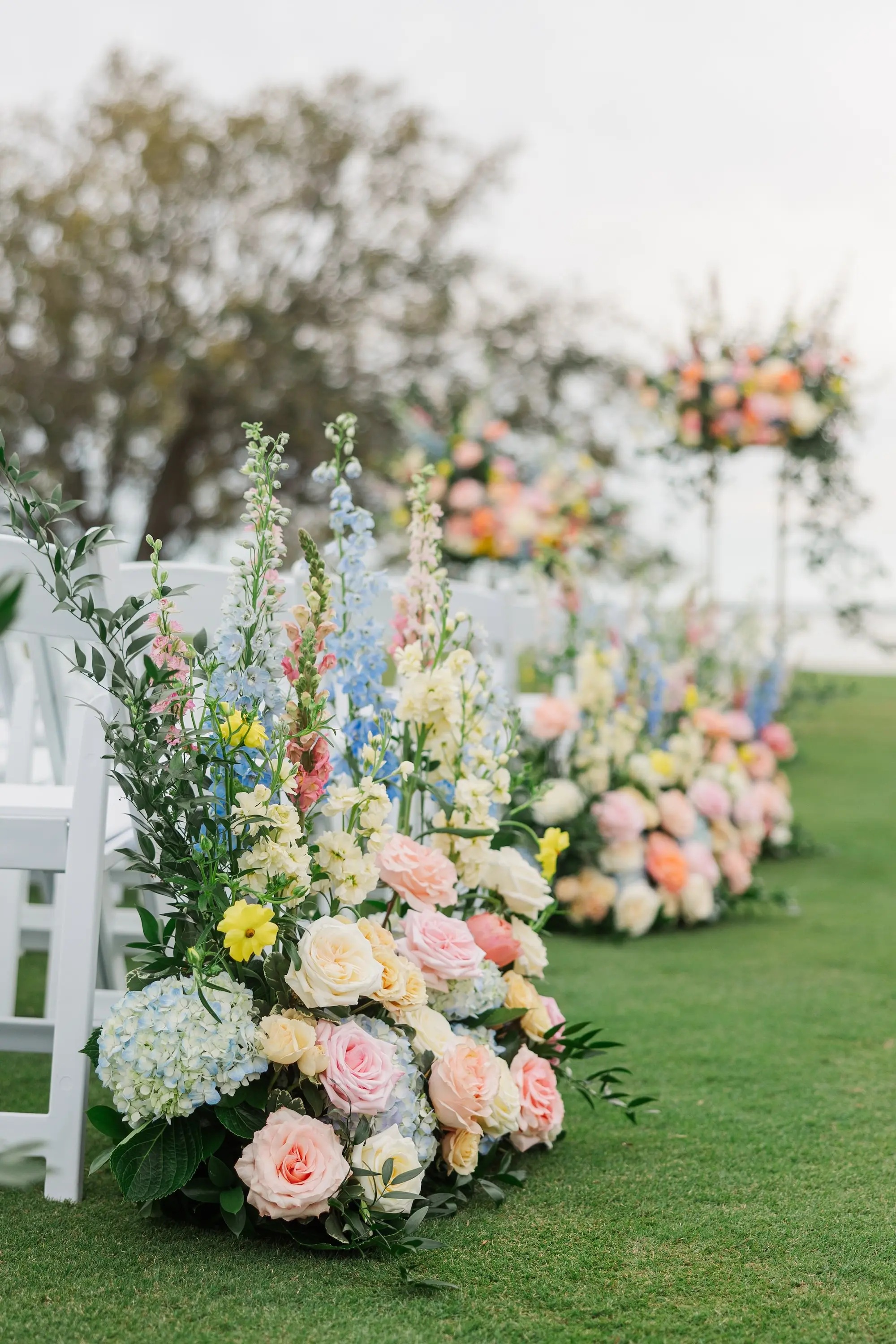 Outdoor Spring Garden Party Wedding Ceremony Aisle Decor Ideas | Pink, Blue, Yellow, White, and Orange Flower Arrangement Inspiration | Tampa Bay Florist Bruce Wayne Florals