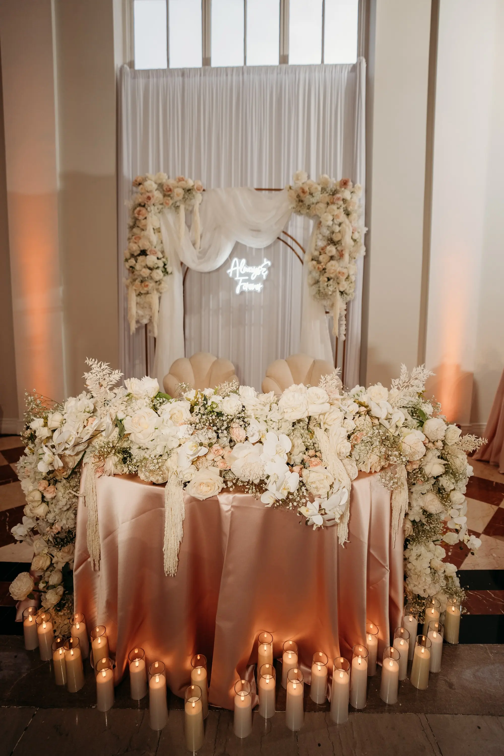Romantic Blush Pink, White, and Champagne Sweetheart Table with Candles Wedding Reception Decor Inspiration with Draping, Backdrop, and Neon Sign
