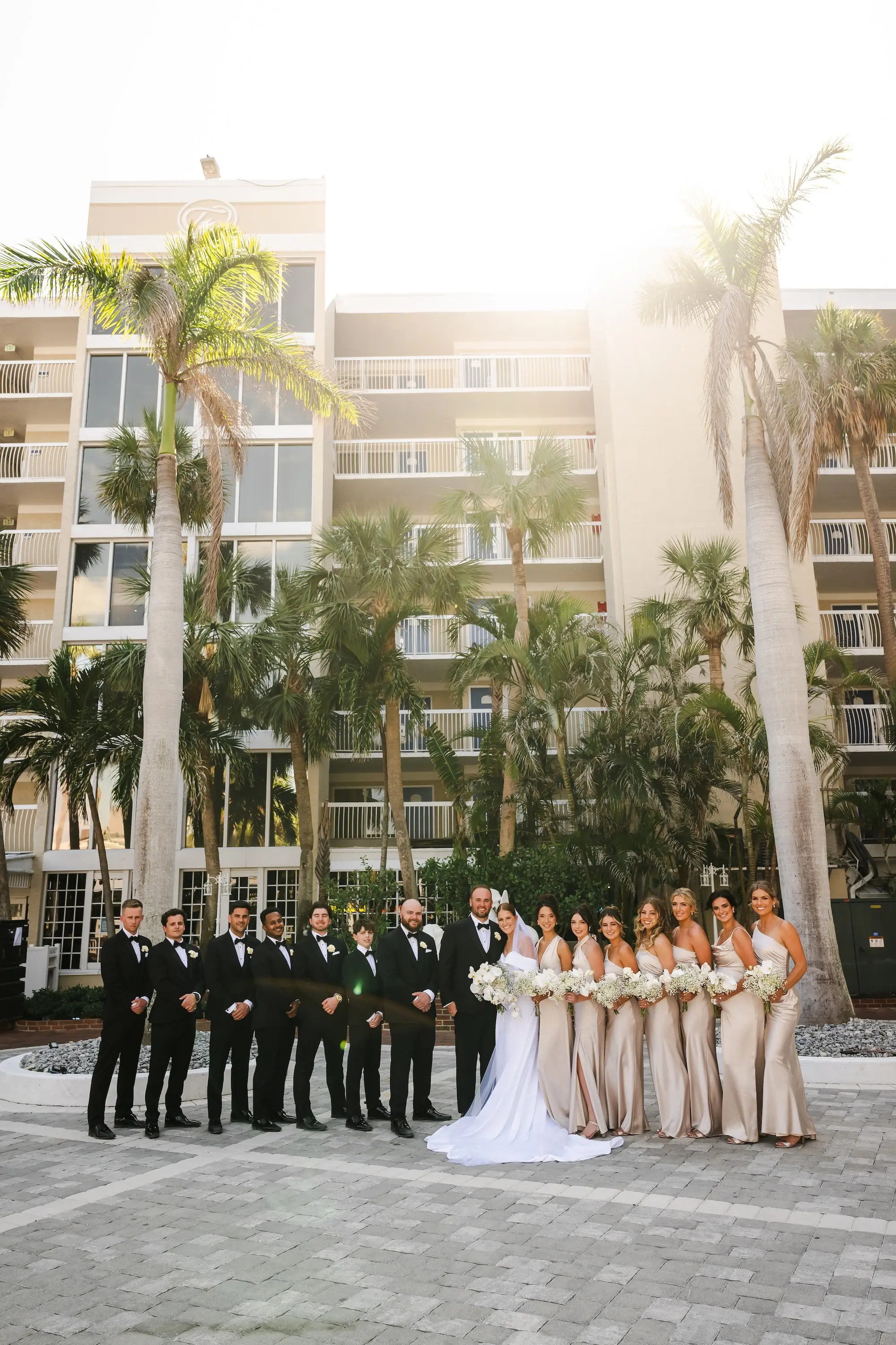Bride and Groom with Wedding Party Portrait | Black Tie Wedding Party Attire Inspiration | Classic Traditional Groomsmen Black Tuxedos Ideas | Different Style Champagne Satin Bridesmaid Dresses Inspiration | Tampa Bay Event Venue TradeWinds Island Resort | St Pete Videographer Photographer Iyrus Weddings