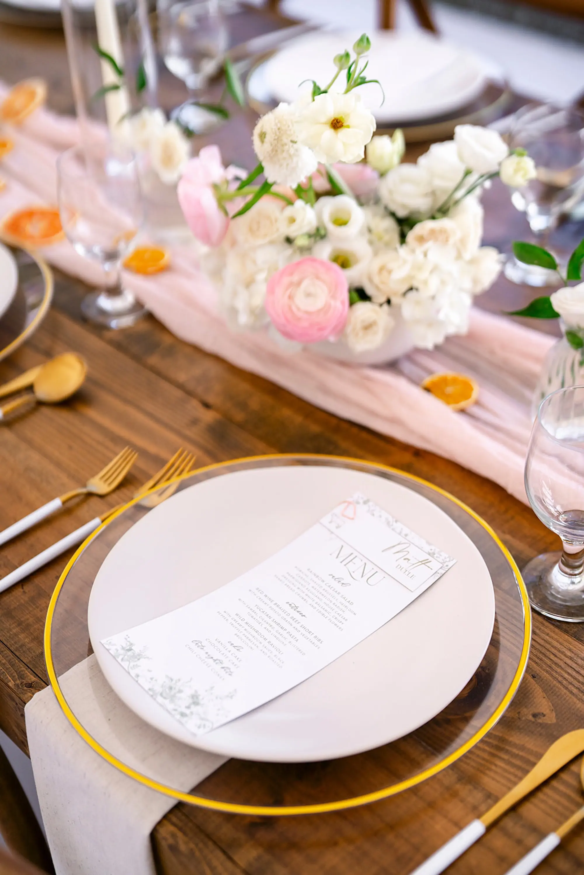 Elegant White and Gold Wedding Reception Place Setting Decor Inspiration | Clear Chargers with Gold Rim and Gold and White Flatware Tablescape Decor Ideas | Light Pink Chiffon Garland with Lush White and Light Pink Floral Centerpiece Decor Inspiration | Tampa Bay Caterer Elite Events Catering | Planner Wilder Mind Events