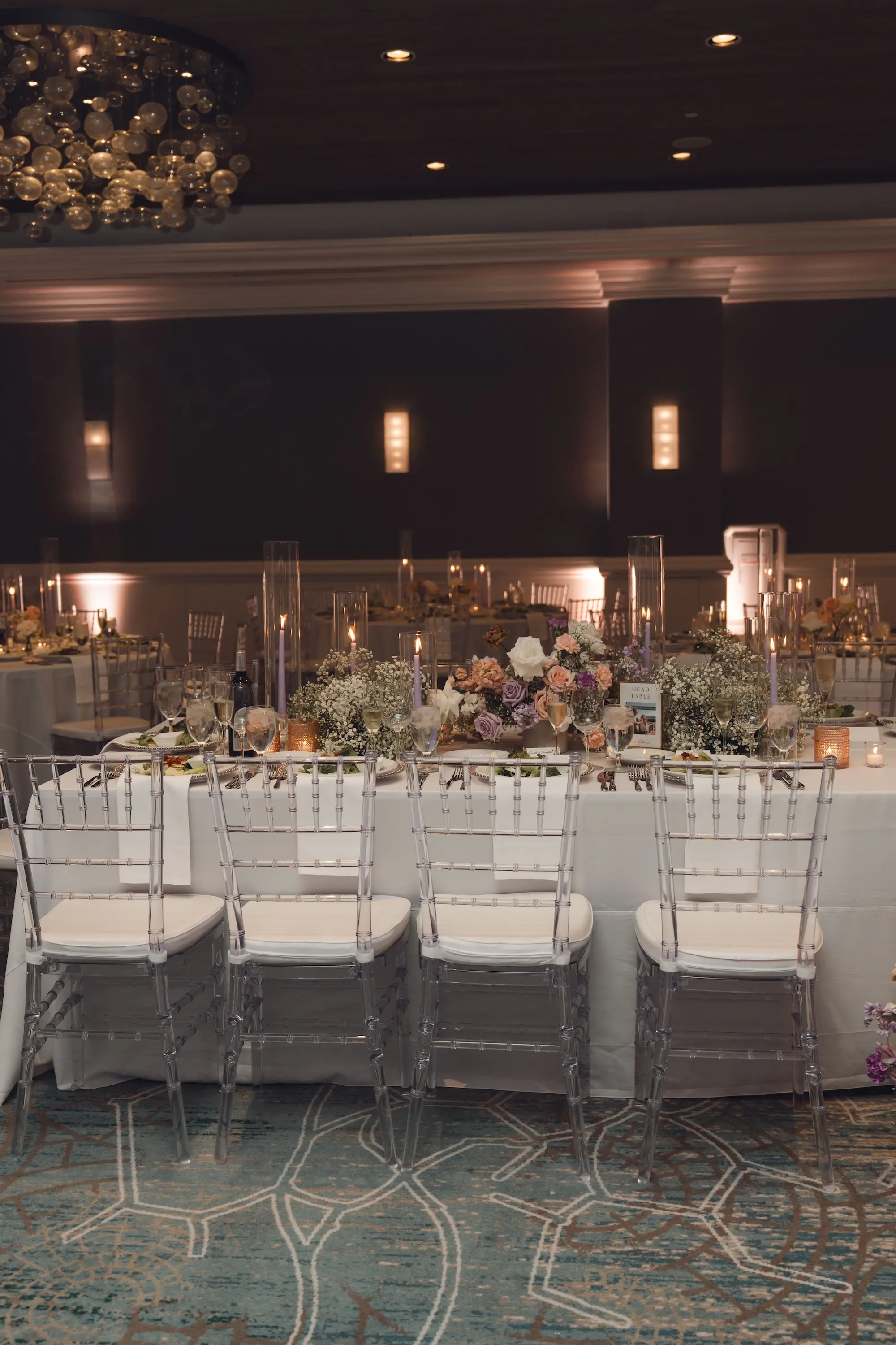 33Modern Disco Themed Florida Wedding Inspiration - Romantic Disco-Themed Florida Wedding | Hyatt Regency Clearwater Beach Luxurious Ballroom Wedding Reception | Modern Ghost Clear Chiavari Chairs | Lush Short Centerpieces with White Peach, Purple, Lavender Flower Arrangement Ideas | Romantic Taper Candles in Glass Vases on White Linens Wedding Reception Decor Inspiration | Venue Hyatt Regency Clearwater Beach Resort and Spa