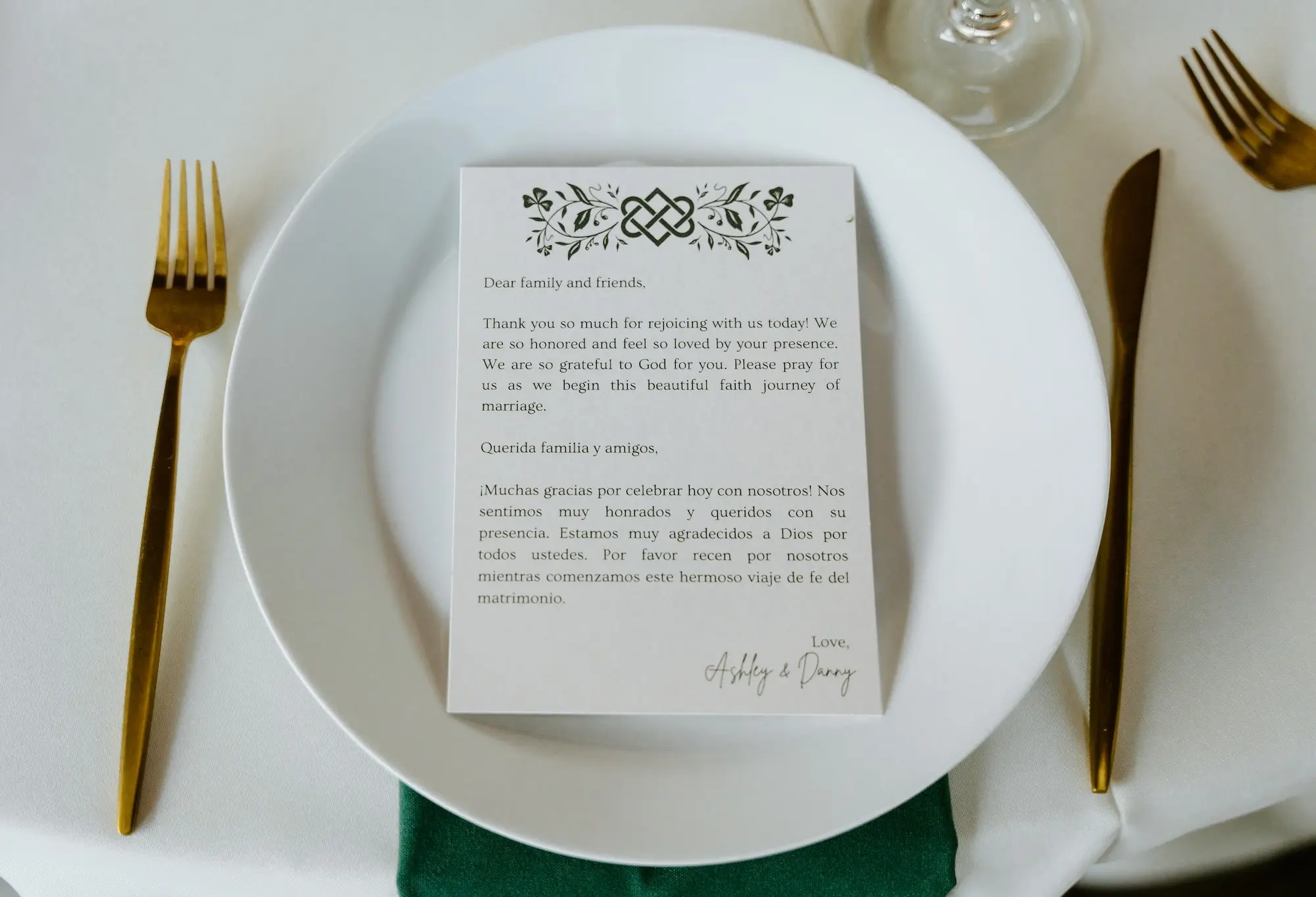 White Table Linen with Gold Flatware and Emerald Green Napkin Wedding Reception Table Decor Ideas | White and Green Celtic Accent Thank You Note in English and Spanish Inspiration
