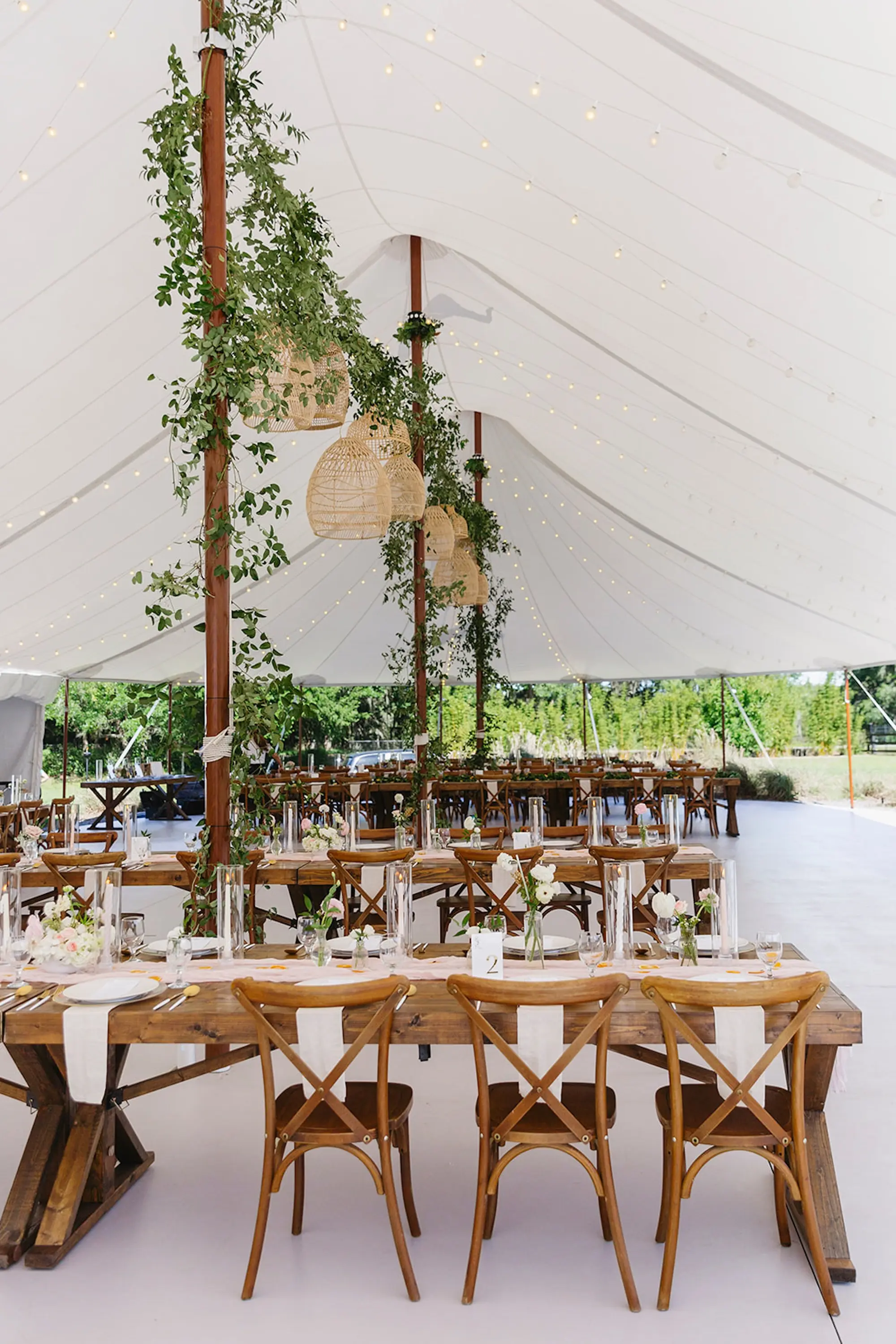 Estate Green Outdoor Tented Wedding Reception Inspiration | Woven Baskets and Eucalyptus Garland Wedding Reception Decor Ideas | Long Wooden Wedding Reception Tables with White Taper Candles Centerpiece Tablescape Decor Inspiration | Tampa Bay Planner Wilder Mind Events | Venue Mill Pond Estate
