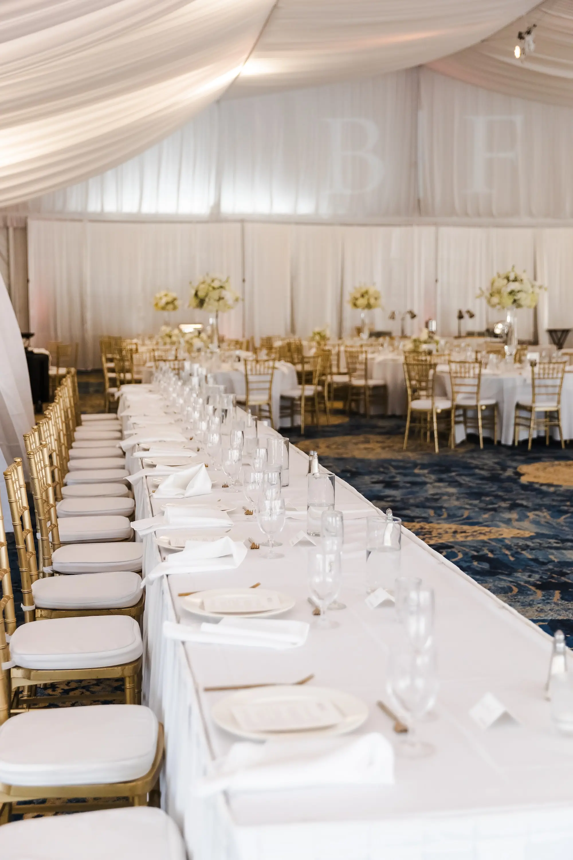 Classic Champagne and Black Florida Beach Tented Ballroom Wedding Reception | Gold Chiavari Chairs at Long Feasting Tables with White Linens Decor Inspiration | St Pete Beach Event Venue TradeWinds Island Resort