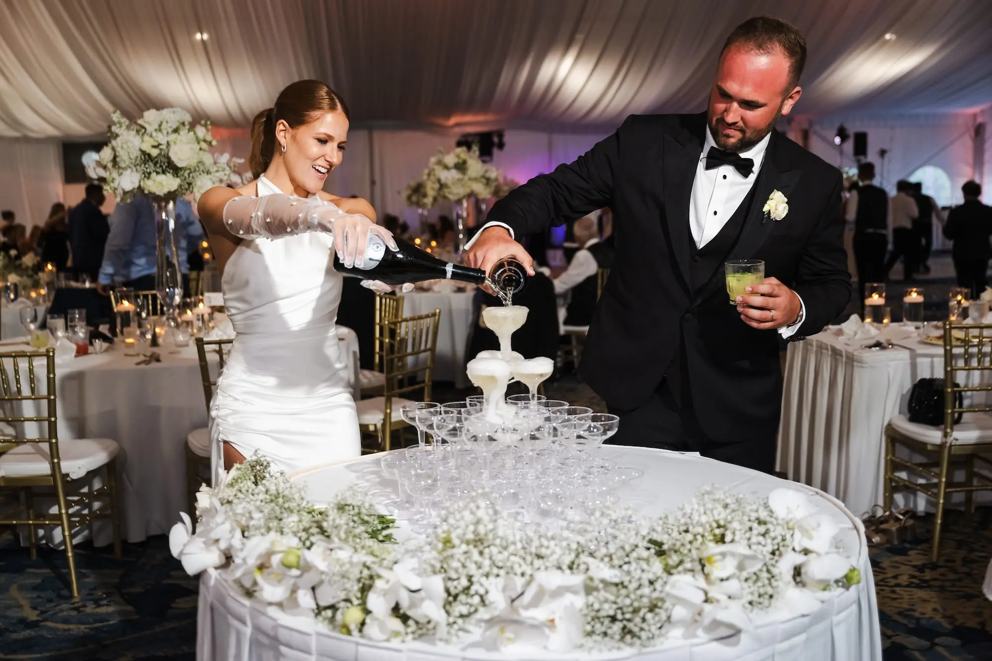 Bride and Groom Champagne Tower Wedding Reception Portrait | Sophisticated Classic White Florals and Baby's Breath Garland Wedding Reception Decor Inspiration | Tampa Bay Photographer Videographer Iyrus Weddings | St Pete Beach Event Venue Tradewinds Island Resort