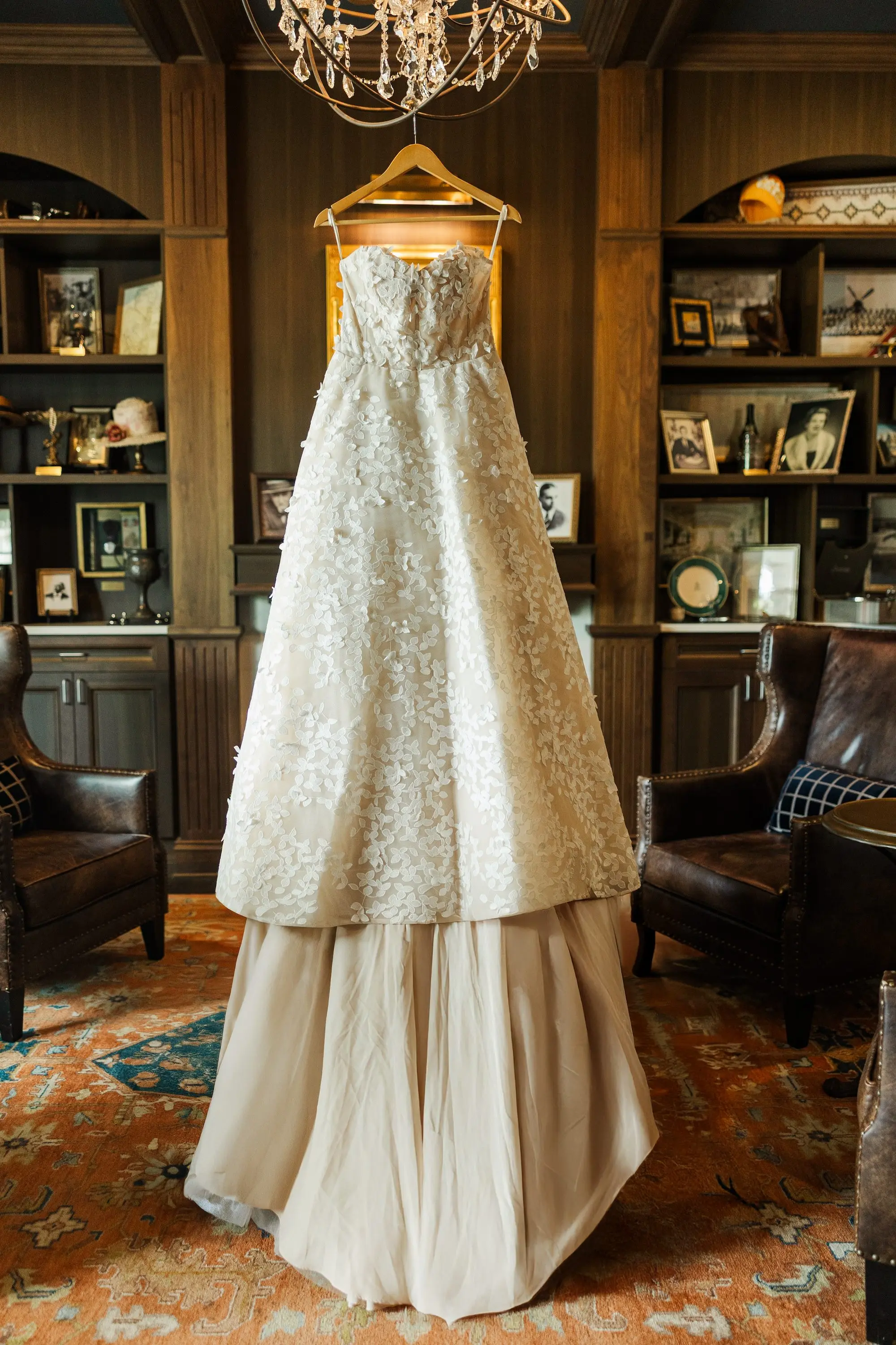 Beige Floral Appliqué Ballgown Atelier Beccar Wedding Dress Hanging from Chandelier in Country Club Clubhouse Inspiration | Floral Lace and Sequin Strapless Sweetheart Neckline and Full Skirt Wedding Gown Ideas