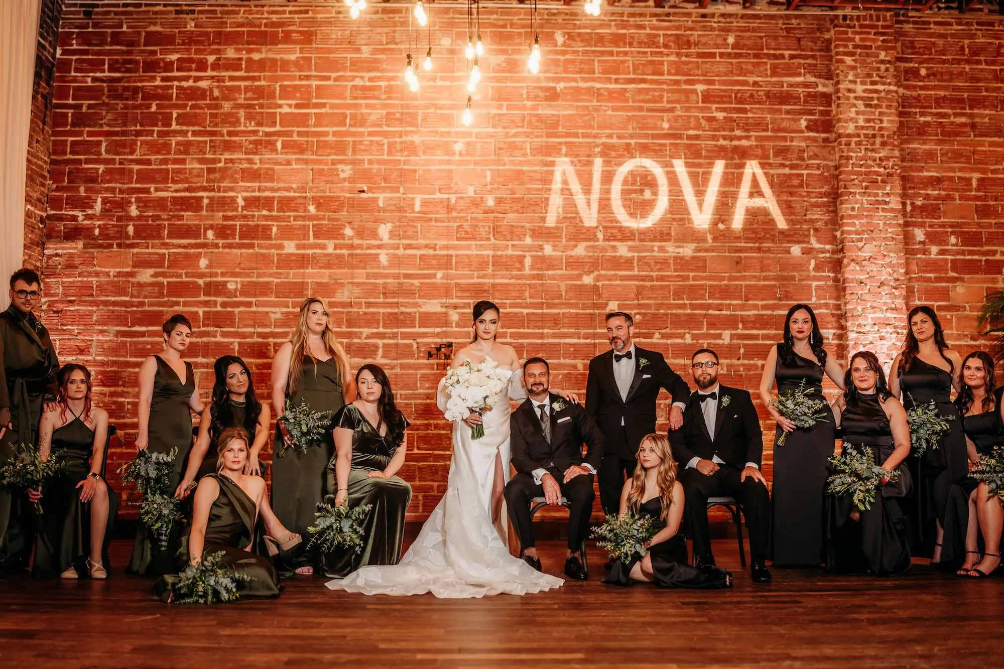 Bride and Groom with Bridal Party Wedding Portrait | Mismatched Olive Green Bridesmaid Dresses Inspiration | Greenery Fern Bridesmaid Bouquet Ideas | Monochromatic White Lilies Bridal Bouquet Inspiration | Downtown St Pete Wedding Venue NOVA 535