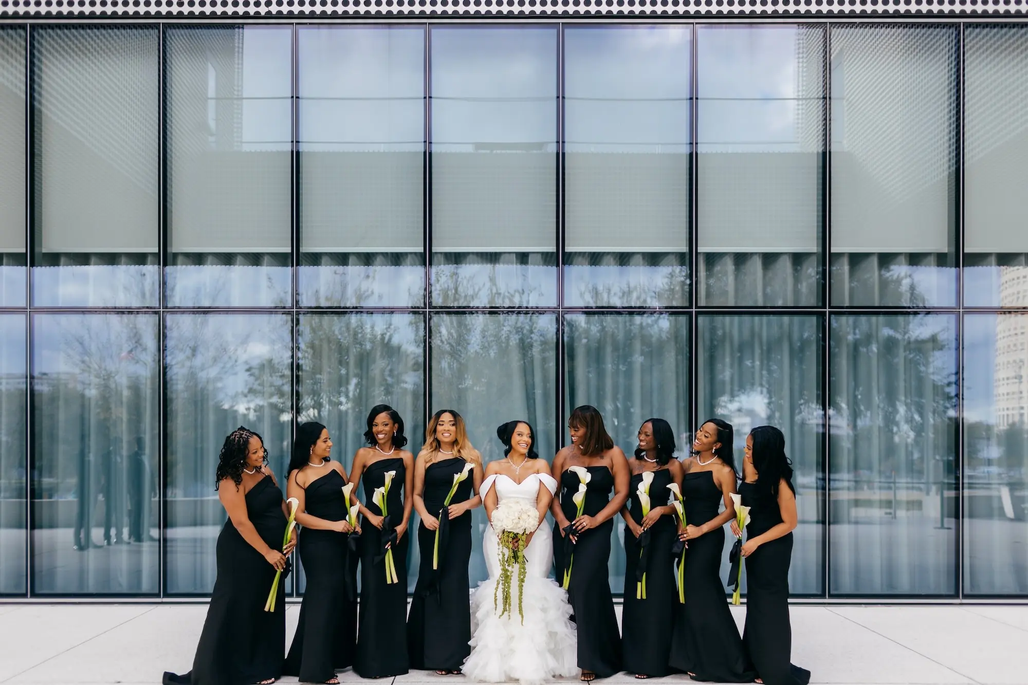 Bride and Bridesmaids Wedding Portrait | Elegant Black Tie Wedding Attire Inspiration | Strapless Black Bridesmaid Dresses Ideas | Long Stem Lilies Bouquet Inspiration | Monochromatic White Bridal Bouquet with Long Stems Ideas