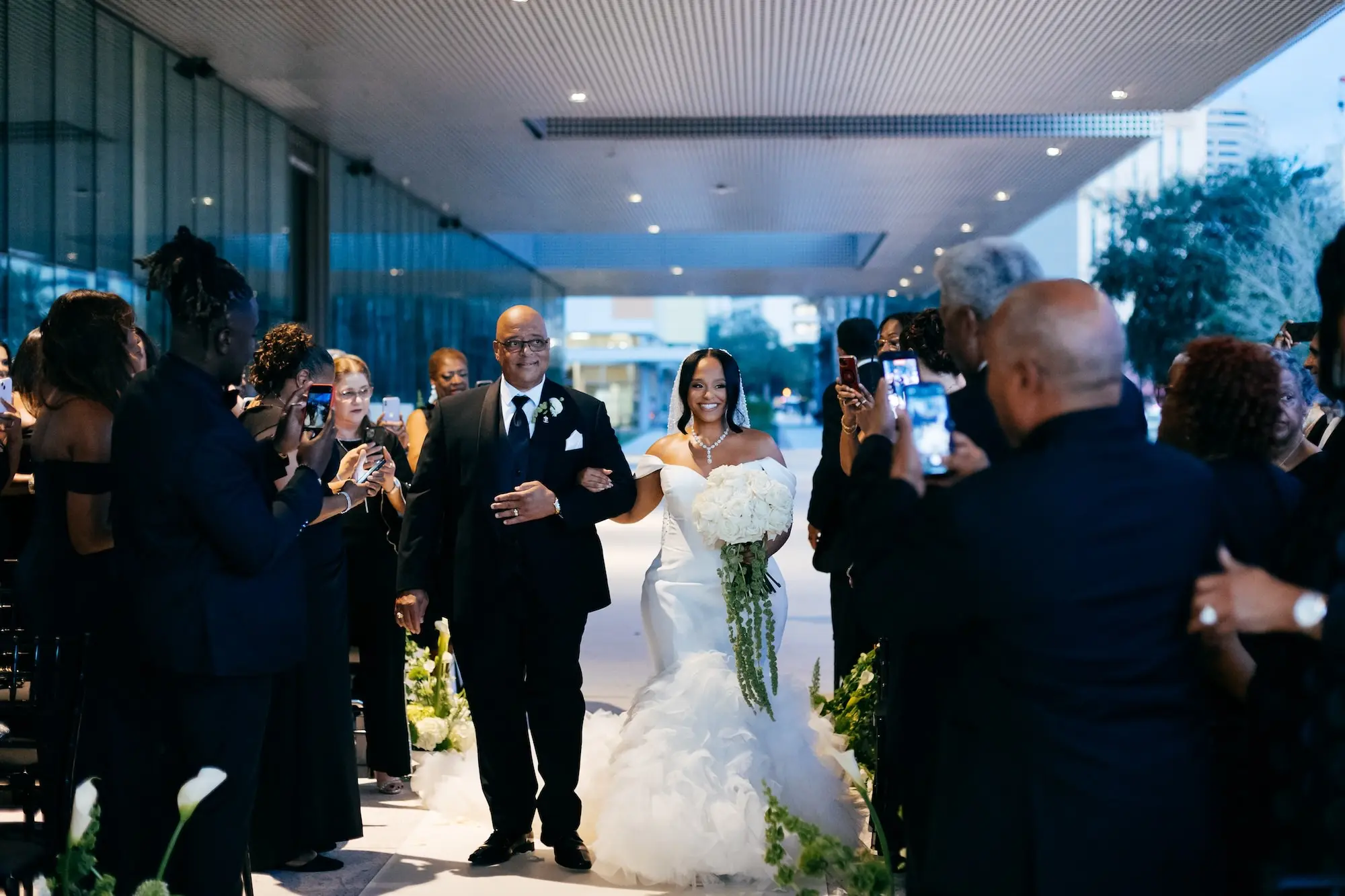 Bride and Father Walking Down Wedding Ceremony Aisle | Monochromatic White Floral Bridal Bouquet with Hanging Green Stems Inspiration | Tampa Bay Wedding Venue Tampa Museum of Art