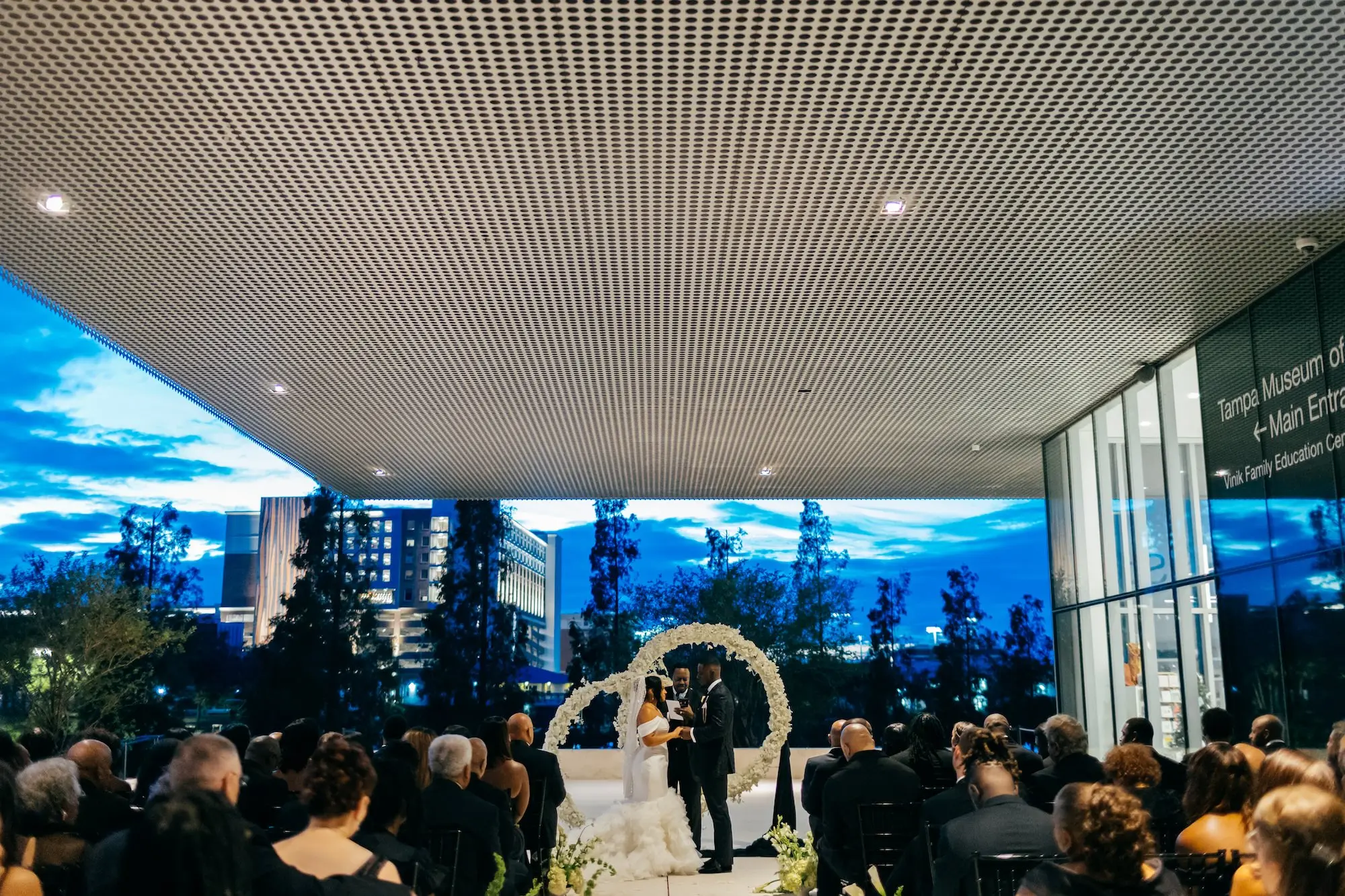 Bride and Groom Wedding Ceremony Vow Exchange Wedding | Elegant Modern Black Tie Night Museum Wedding Ceremony Inspiration | Monochromatic White Circle Altar Decor Ideas | Wedding Venue Tampa Museum of Art | Tampa Bay Event Planner Unique Weddings and Events