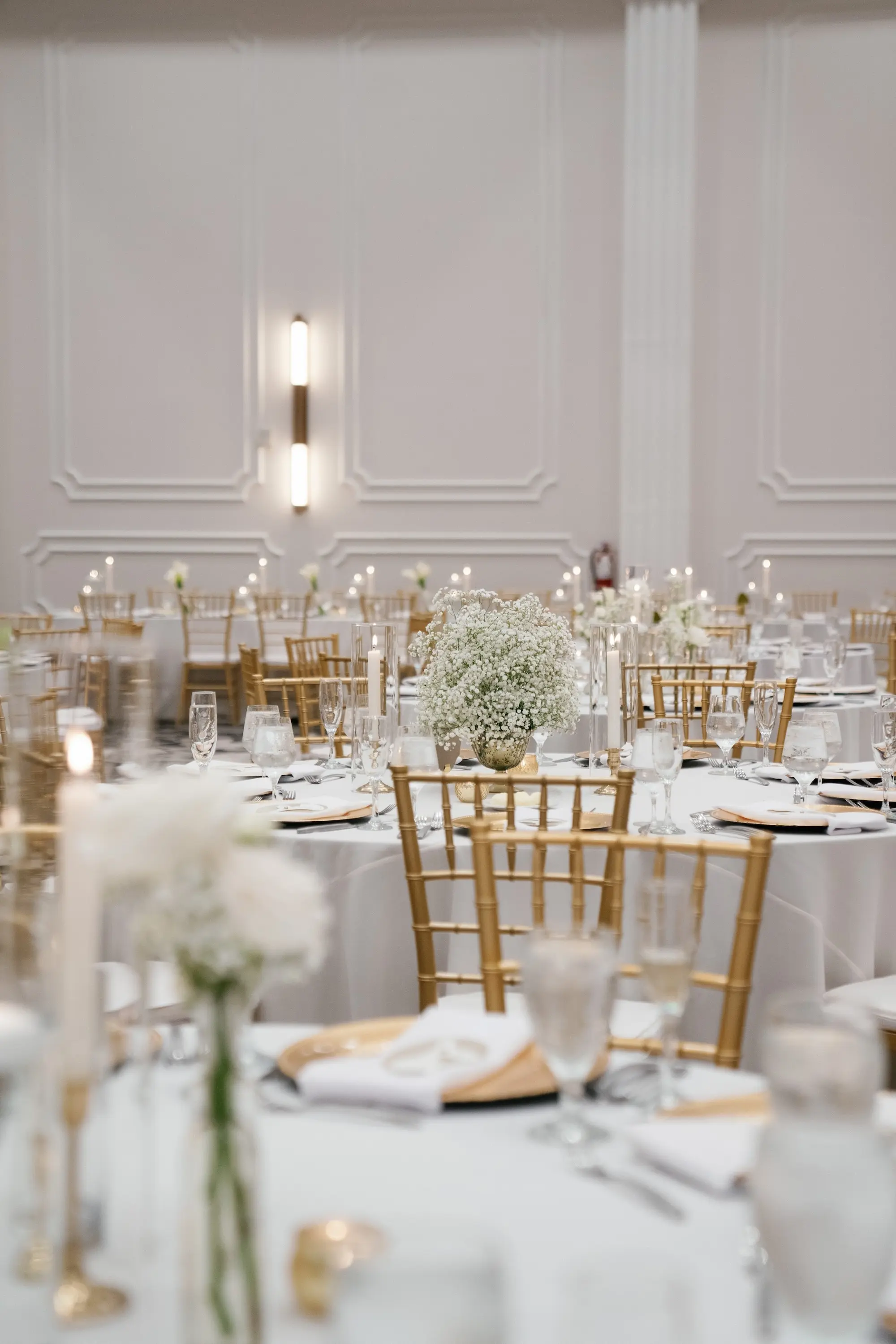 Elegant Ballroom White and Gold Wedding Reception Inspiration | Gold Chiavari Chairs at Round Tables with White Linens Decor Ideas | Gold Chargers with White Napkins and Romantic White Floral Centerpieces with Tea Candles Decor Inspiration | Historic Tampa Venue Hotel Flor