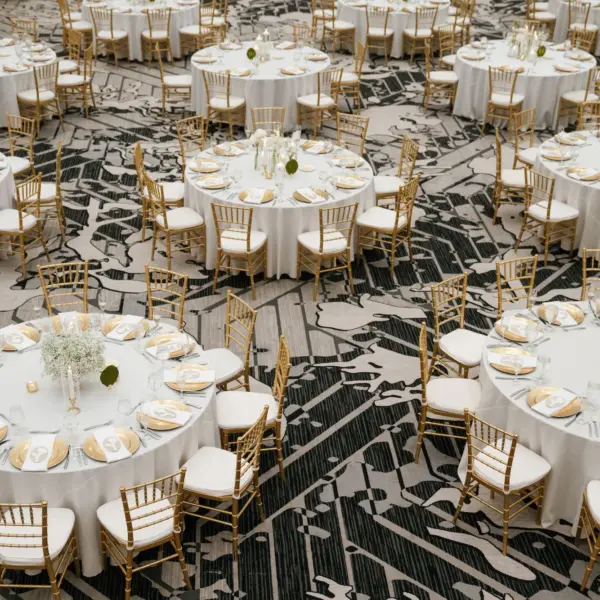 Elegant Ballroom White and Gold Wedding Reception Inspiration | Gold Chiavari Chairs at Round Tables with White Linens Decor Ideas | Gold Chargers with White Napkins and Romantic White Floral Centerpieces with Tea Candles Decor Inspiration | Historic Tampa Venue Hotel Flor